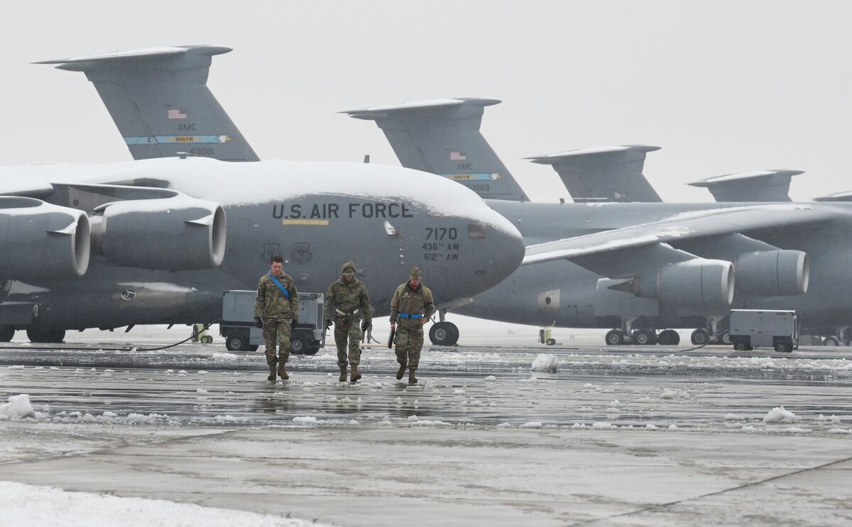 Maintainers walk across the flightline