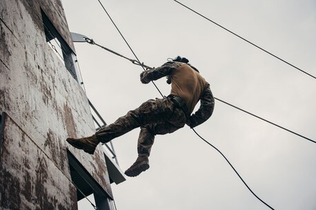 A U.S. Marine with the Battalion Landing Team 1/6, 26th Marine Expeditionary Unit (Special Operations Capable) (MEU(SOC)), rappels down a tower during fast rope and rope suspension training at Naval Support Activity Souda Bay, on the island of Crete, Greece, Dec. 18, 2023. U.S. Marines and Sailors of the 26th Marine Expeditionary Unit (Special Operations Capable), embarked on the ships of the Bataan Amphibious Ready Group, are on a scheduled deployment with elements deployed to the U.S. 5th Fleet and U.S. 6th Fleet areas of operation to increase maritime security and stability, and to defend U.S., Allied, and Partner interests. (U.S. Marine Corps photo by Cpl. Aziza Kamuhanda)