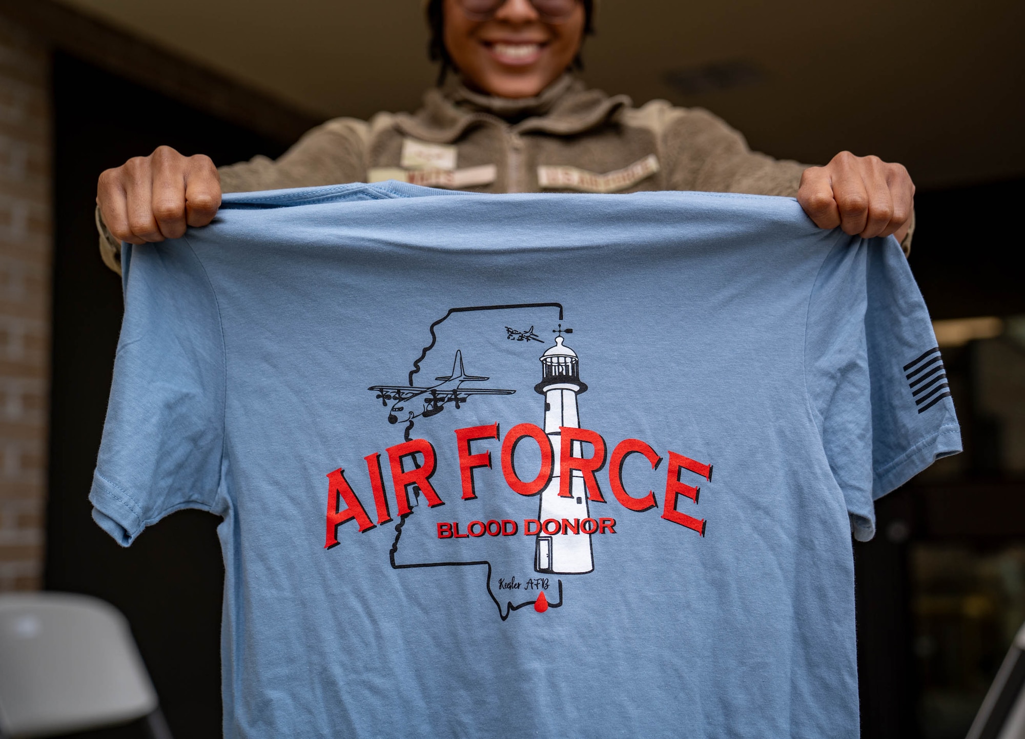 U.S. Air Force Airman 1st Class Devyn Waits, 81st Training Wing public affairs specialist, holds up a t-shirt at the Triangle Clinic on Keesler Air Force Base, Mississippi, Jan. 18, 2024.