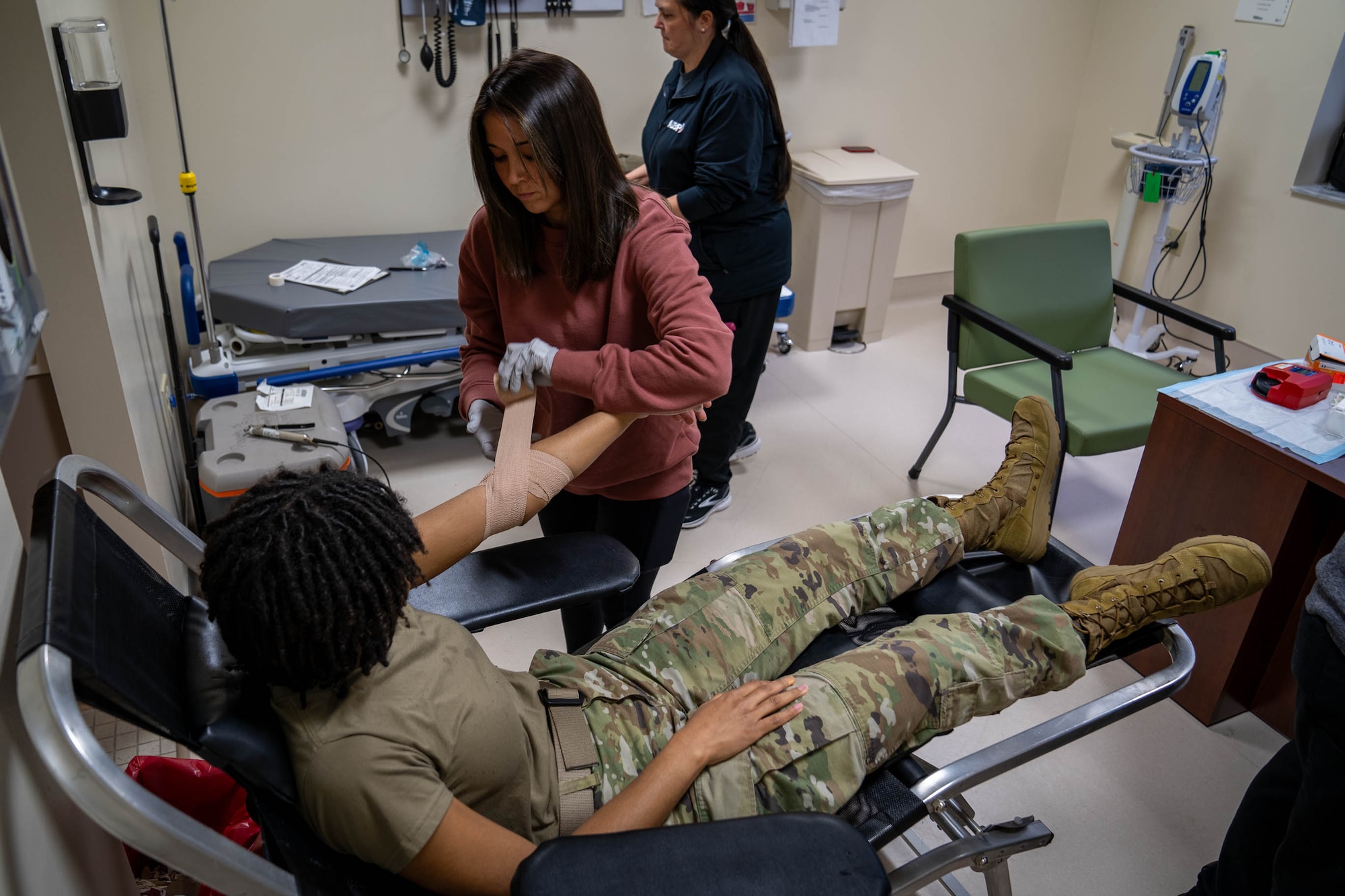 U.S. Air Force Airman 1st Class Devyn Waits, 81st Training Wing public affairs specialist, has her arm wrapped by Emilie Canlas, 81st Medical group lab technician, after donating blood at the Triangle Clinic on Keesler Air Force Base, Mississippi, Jan. 18, 2024.
