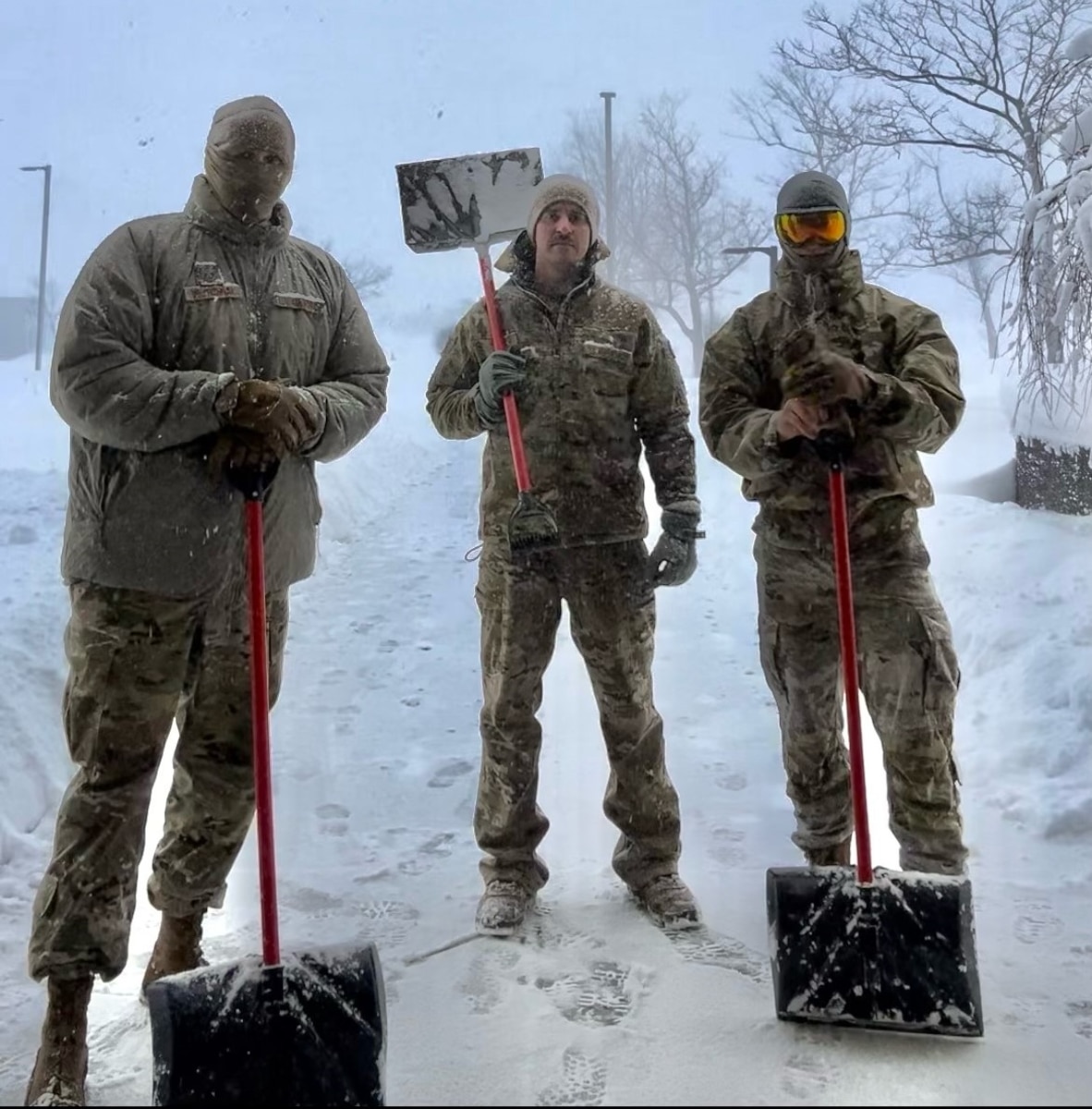 Staff Sgt. Nathan Wojtkowiak, Tech. Sgt. Kevin Pawlukovich and Staff Sgt. Jacob Qualiana, assigned to the 107th Attack Wing, pause from keeping entrances clear at Erie Community South Campus warming station in Orchard Park, New York, Jan. 15, 2024. Seasonally activated warming stations established around Western New York provide stranded and homeless civilians refuge from extreme winter conditions.