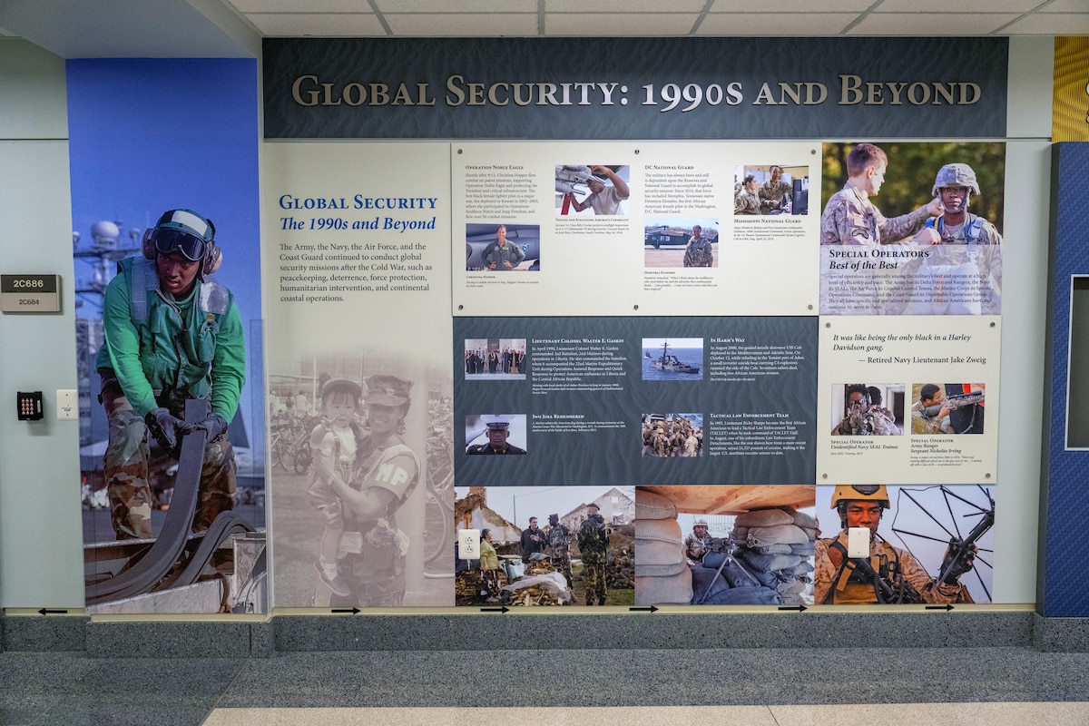 An infographic depicting African Americans who served in the military during Global Security: 1990s and beyond is displayed with pictures and text on a wall.