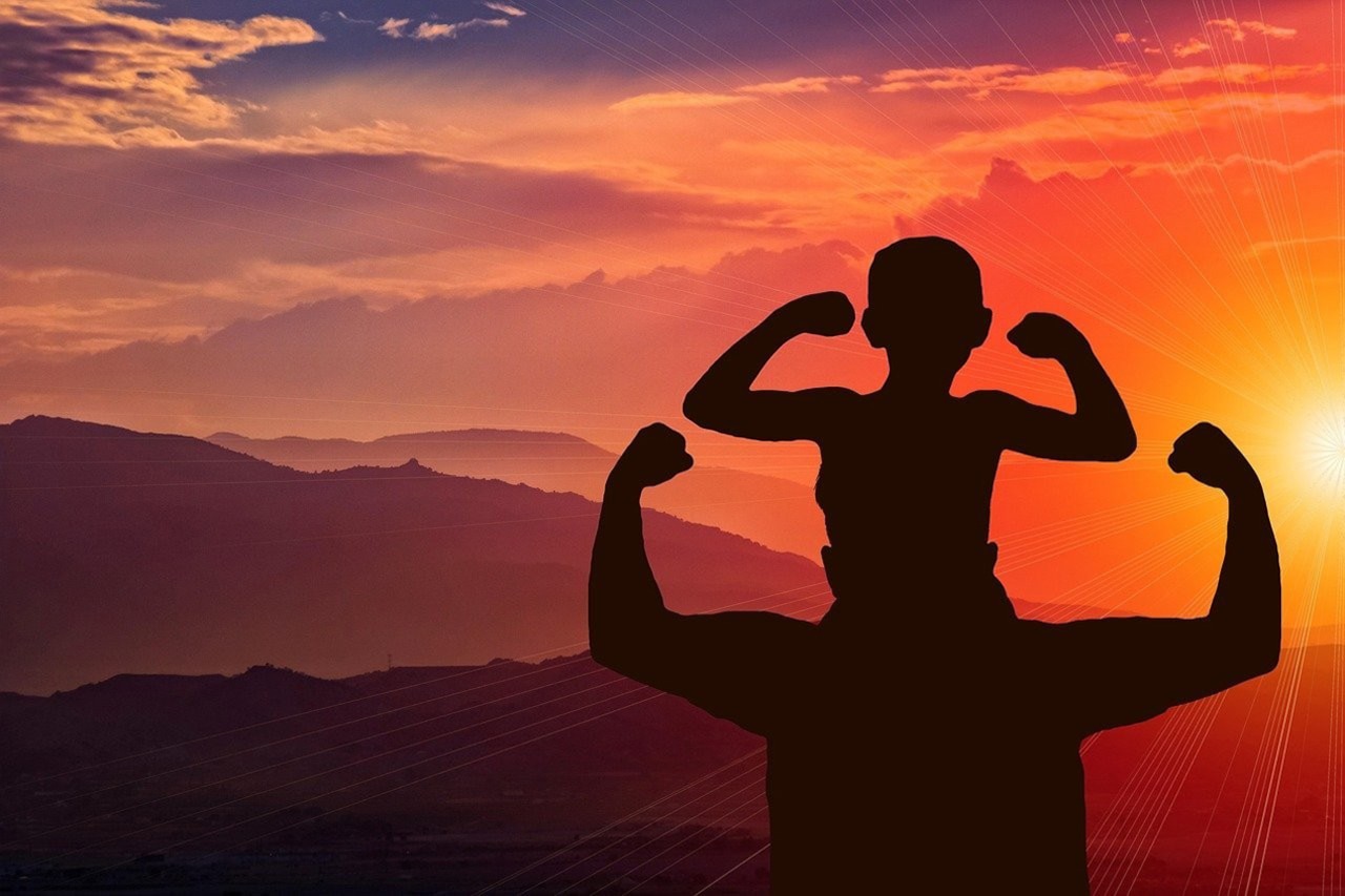 Illustration of a parent holding a child on their shoulders and both of them show off their muscles on top of a mountain with the sun setting in the background.
