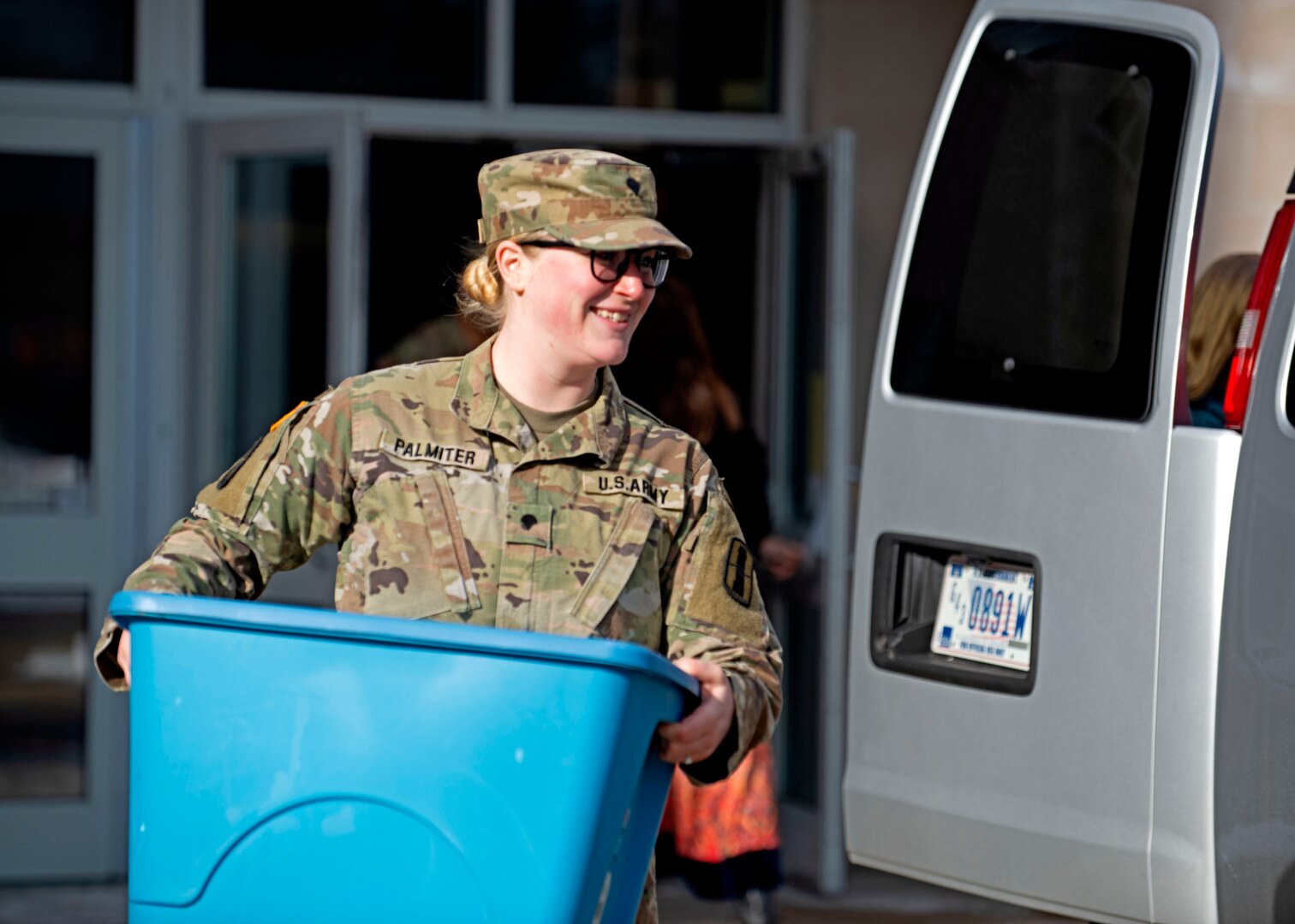 Spc. Olivia Palmiter, international support specialist with Joint Force Headquarters, New Hampshire Army National Guard, helps load donated books into a cargo van Jan. 17, 2024, at Bow High School, New Hampshire.