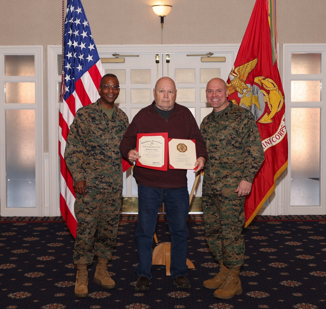 Robert G. Garner, a shop planner with Facilities Management Section, poses with U.S. Marine Corps Col. Michael L. Brooks, a South Boston, Virginia, native and base commander of Marine Corps Base Quantico, left, and Sgt. Maj. Michael R. Brown, a Jacksonville, Florida, native and sergeant major, MCINCR-MCBQ, during the Civilian Quarterly Awards at The Clubs at Quantico, MCINCR-MCBQ, Virginia, Jan. 11, 2024. Garner was recognized and awarded for his 50 years of federal service. (U.S. Marine Corps photo by Lance Cpl. David Brandes)