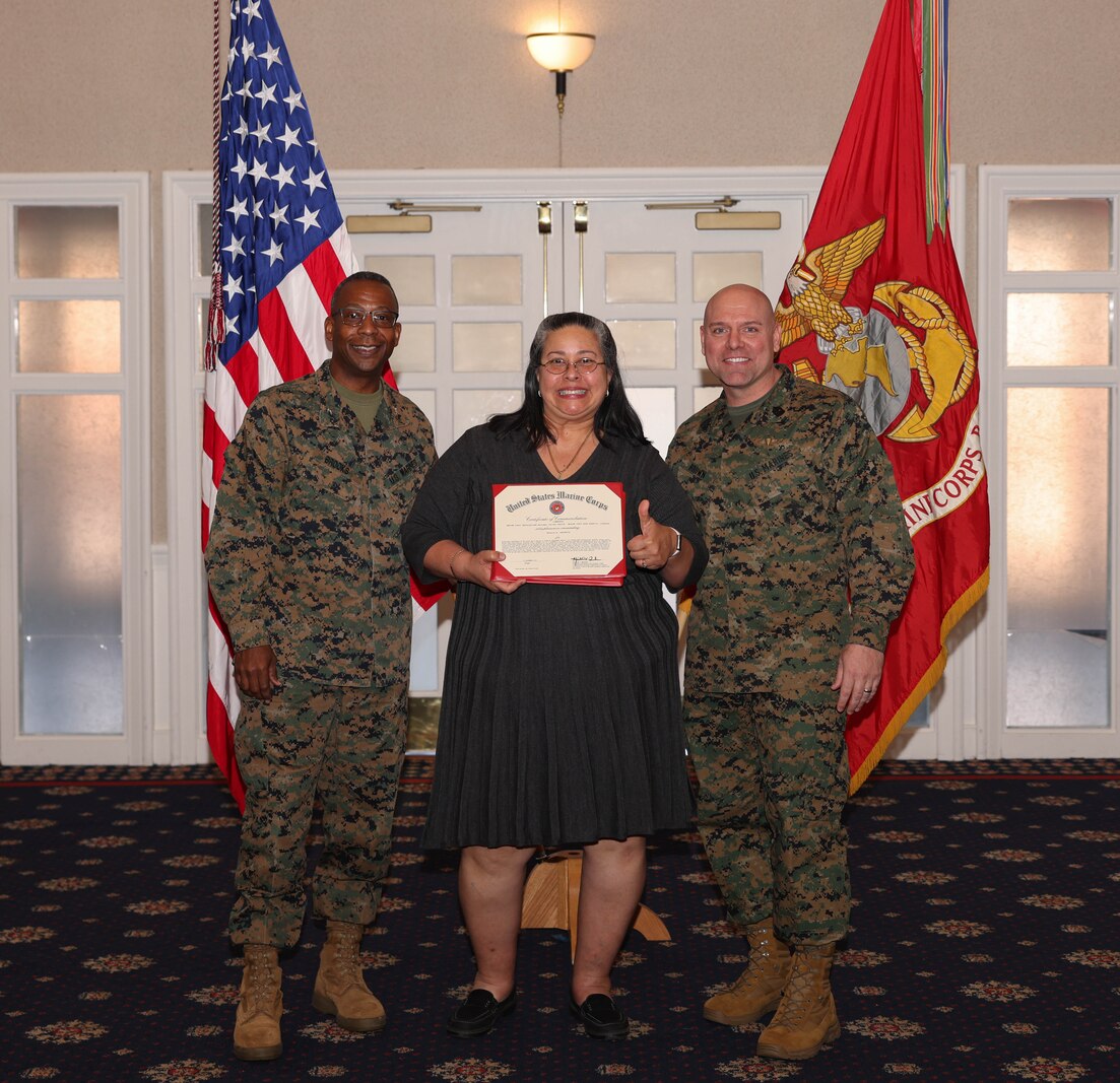 Natalia M. Checknita, a financial management analyst with Facilities Directorate, poses with U.S. Marine Corps Col. Michael L. Brooks, a South Boston, Virginia, native and base commander, Marine Corps Base Quantico, left, and Sgt. Maj. Michael R. Brown, a Jacksonville, Florida, native and sergeant major, MCINCR-MCBQ, during the Civilian Quarterly Awards at The Clubs at Quantico, MCINCR-MCBQ, Virginia, Jan. 11, 2024. Checknita was recognized with the Senior Appropriated Fund Personnel Civilian Employee of the Quarter Award for work done in the 4th quarter of 2023.  (U.S. Marine Corps photo by Lance Cpl. David Brandes)