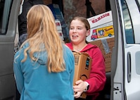 From left, ninth graders Charlotte Weiss and Stella Wantuck help load donated books into a cargo van Jan. 17, 2024, at Bow High School.