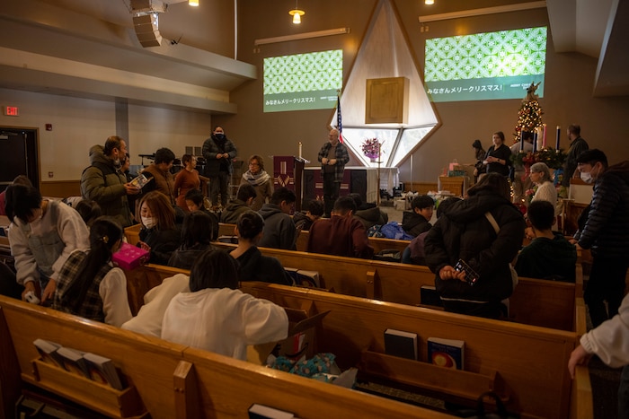 Members and volunteers of the Misawa Air Base Chapel and the Biko-en Children's Care Facility open and hand out gifts during an Orphanage Angel Tree Gifts and Pool Party at Misawa Air Base, Japan, Dec. 16, 2023.