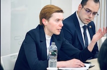 a men and a women seated at a table in a discussion