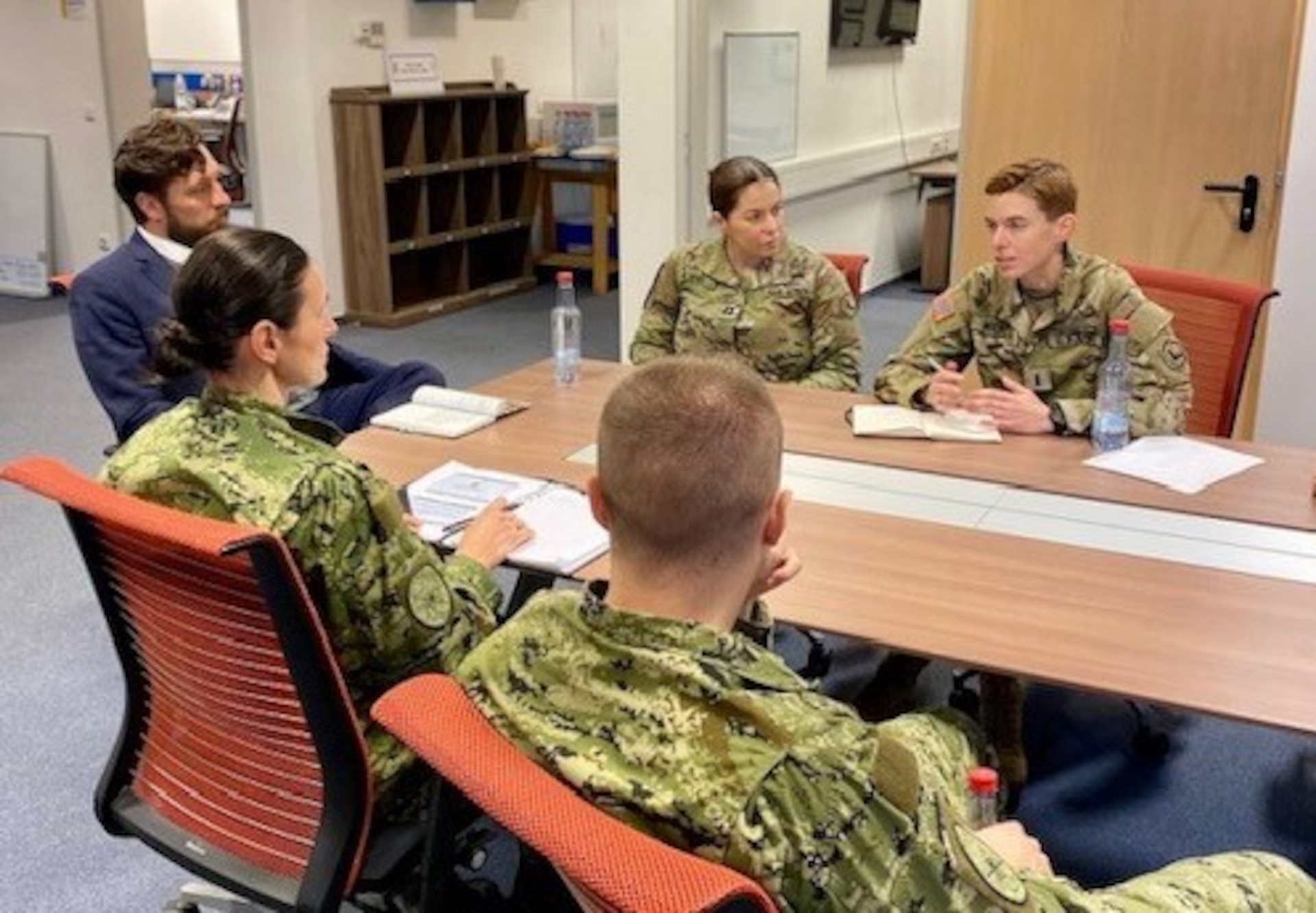 group of men and women seated at a table in a discussion