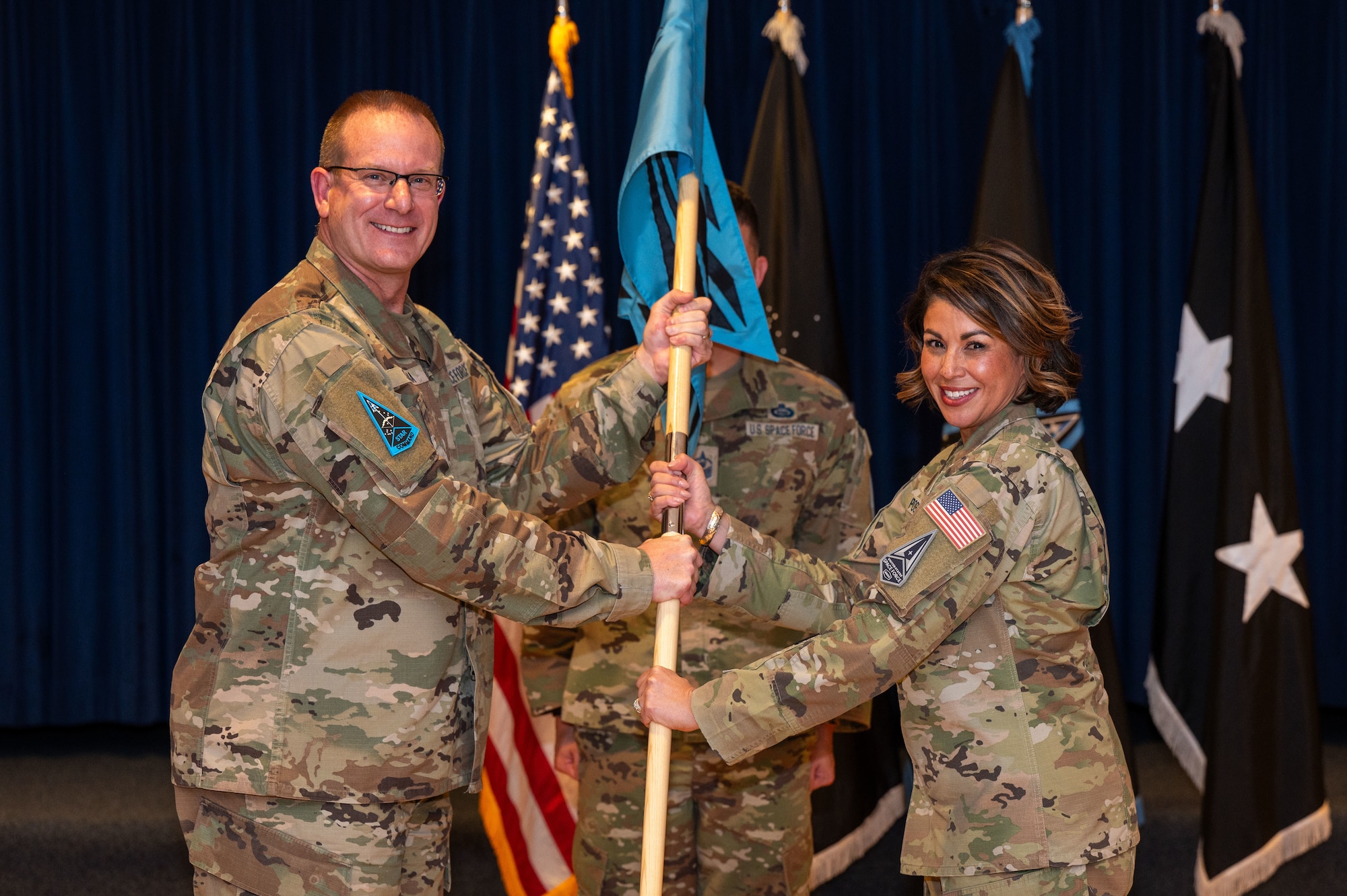 U.S. Space Force Chief Master Sgt. Karmann-Monique Pogue accepts the unit guidon from Maj. Gen. Timothy Sejba, commander of Space Training and Readiness Command, during a change of responsibility ceremony at Peterson Space Force Base, Colorado, Jan. 19, 2024. During the ceremony, Pogue succeeded Chief Master Sgt. James Seballes as the second senior enlisted leader of STARCOM. (U.S. Space Force photo by Ethan Johnson)