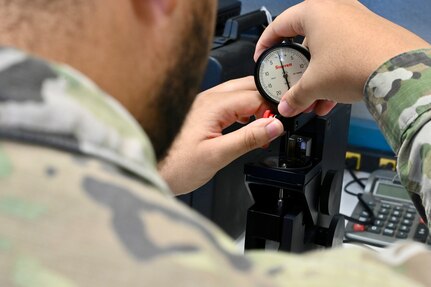 Spc. John Parker, a District of Columbia National Guard electronics and calibration technician within the Test Measurement Diagnostic Equipment (TMDE) section, inspects a dial pressure gauge at the Surface Equipment Maintenance Facilities/Combined Support Maintenance Shop at Joint Base Anacostia-Bolling, Jan. 18, 2024. Standardized measurements ensure weapons systems from aircraft to mission-critical vehicles operate safely and effectively.