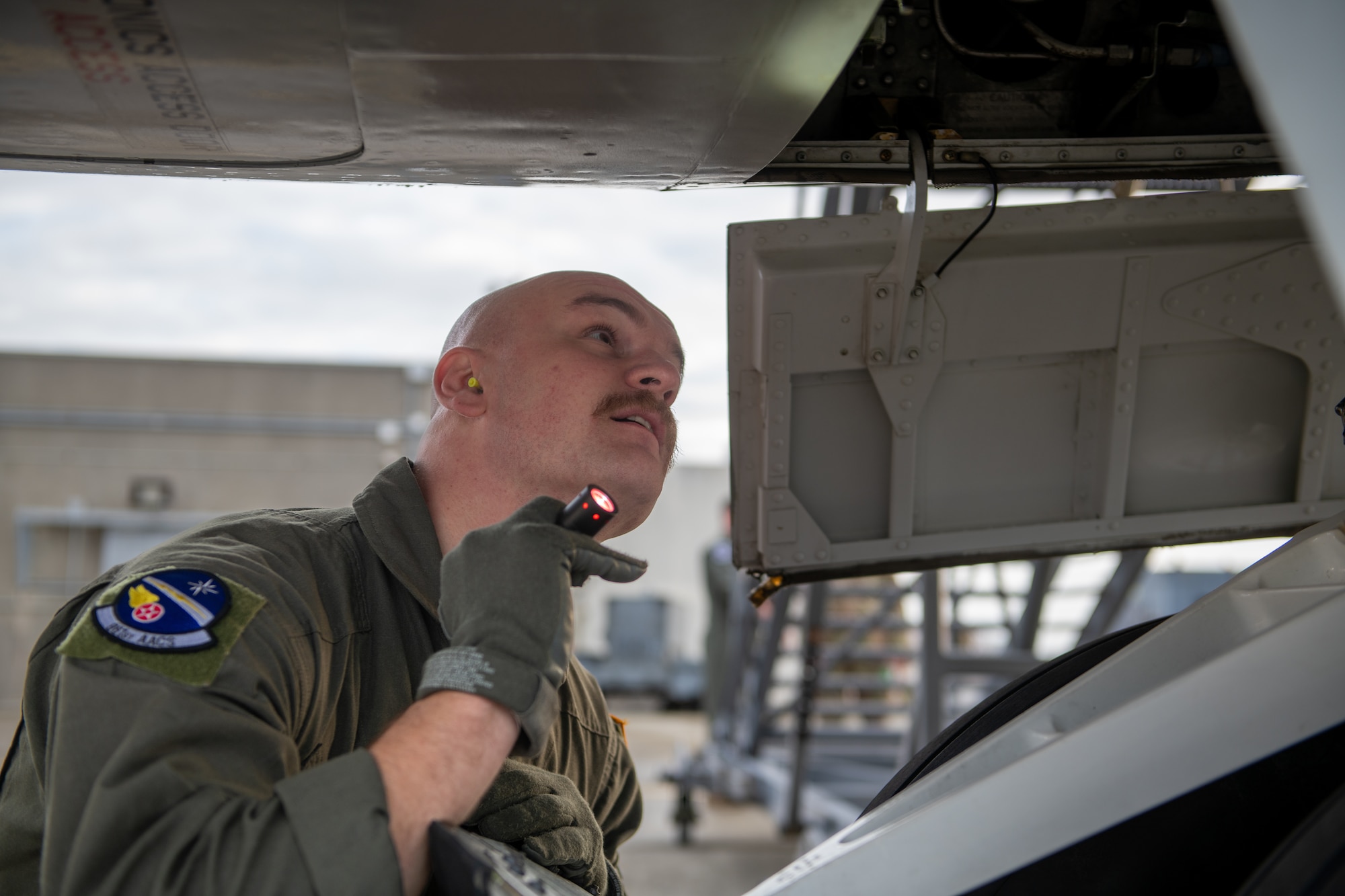 A man performs pre-flight checks on an E-3 sentry.