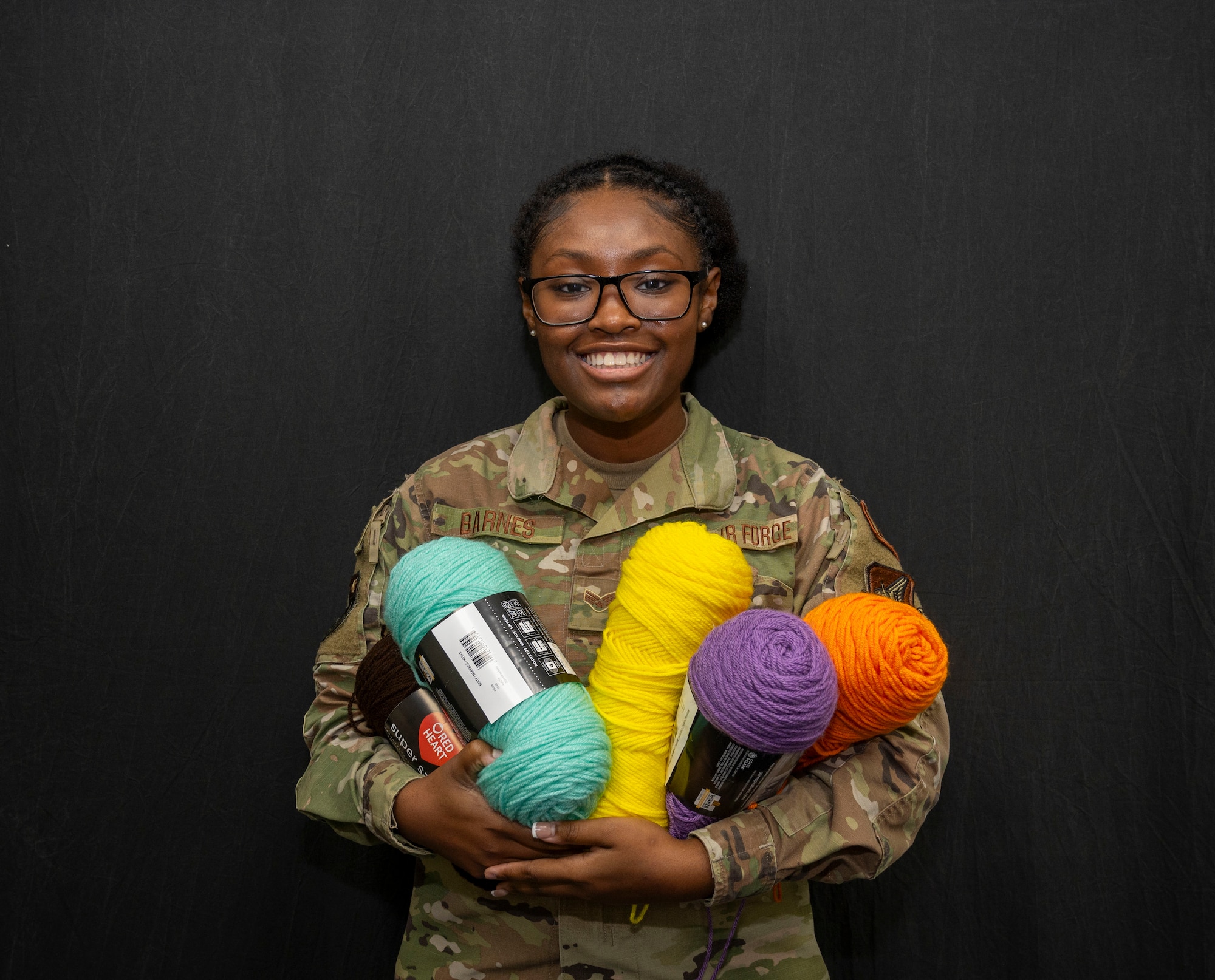 U.S. Air Force Senior Airman Jasmine Barnes, 36th Wing Public Affairs Journeyman, poses with her yarn at Andersen Air Force Base, Guam, Jan. 22, 2024. Barnes spends her free time making rugs after work as a way to be creative and decompress. (U.S. Air Force photo by Senior Airman Akeem Campbell)