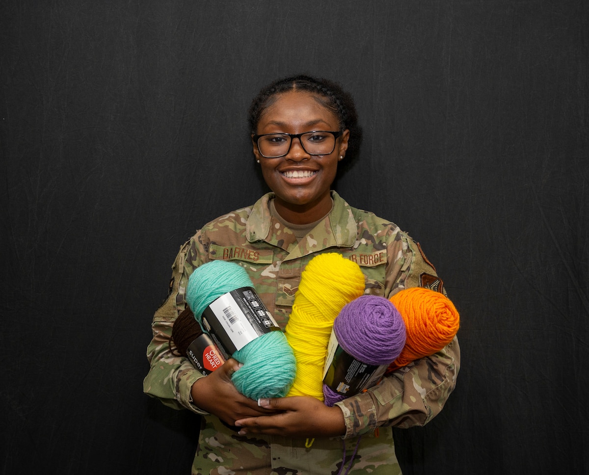 U.S. Air Force Senior Airman Jasmine Barnes, 36th Wing Public Affairs Journeyman, poses with her yarn at Andersen Air Force Base, Guam, Jan. 22, 2024. Barnes spends her free time making rugs after work as a way to be creative and decompress. (U.S. Air Force photo by Senior Airman Akeem Campbell)