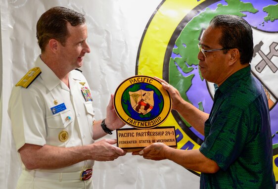 President Wesley Simina, president of the Federated States of Micronesia, right, presents U.S. Navy Rear Adm. Mark Melson,  commander of Task Force 73, left, with a gift during the Chuuk closing ceremony aboard the hospital ship USNS Mercy (T-AH 19), anchored off Chuuk, Federated States of Micronesia, as part of Pacific Partnership 2024-1, Jan. 20, 2024. Pacific Partnership, now in its 19th iteration, is the largest multinational humanitarian assistance and disaster relief preparedness mission conducted in the Indo-Pacific and works to enhance regional interoperability and disaster response capabilities, increase security stability in the region, and foster new and enduring friendships. (U.S. Navy photo by Mass Communication Specialist 2nd Class Celia Martin)