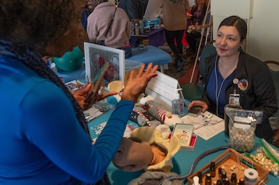 An obstetrics gynecology clinic midwife, takes questions at her booth during the Women’s Health Fair.