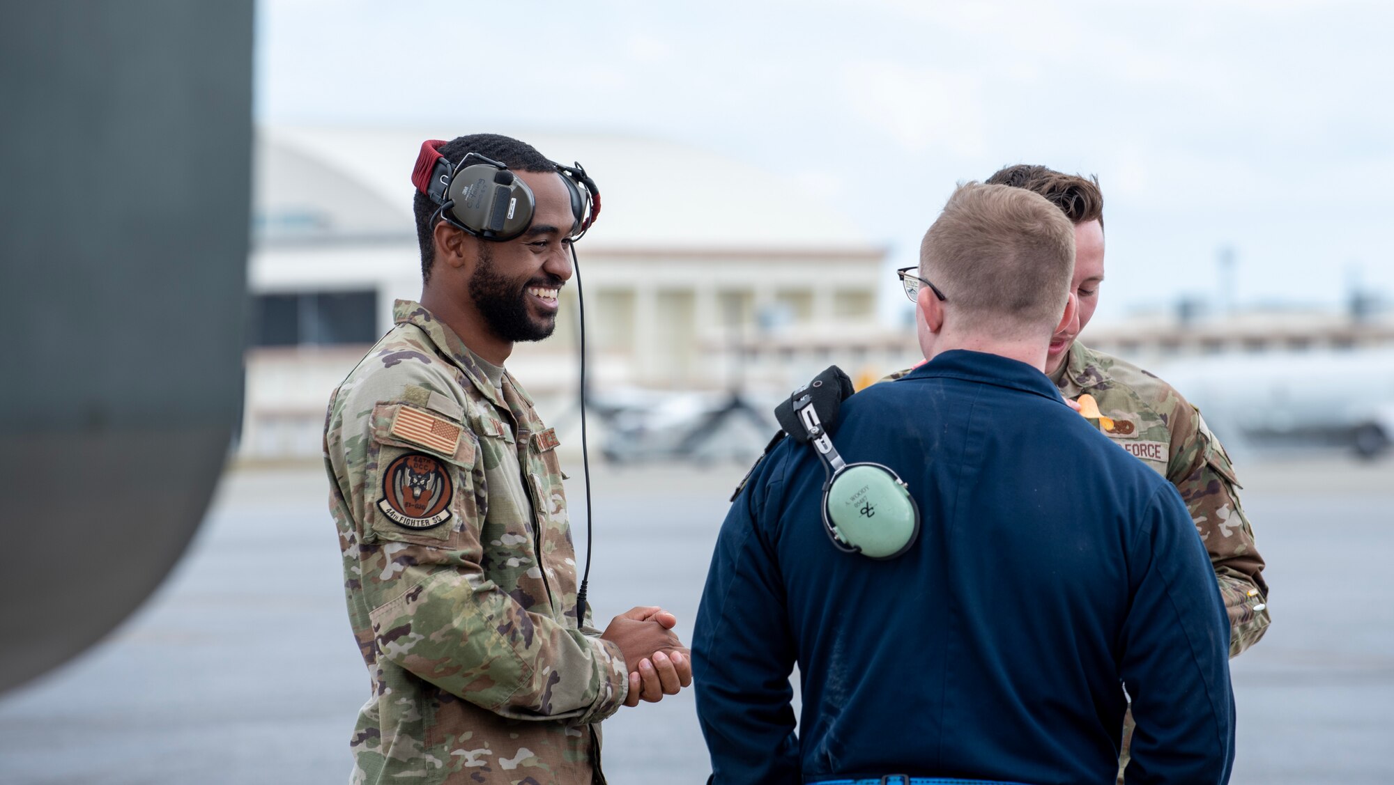 airmen smiling and talking on the flight line