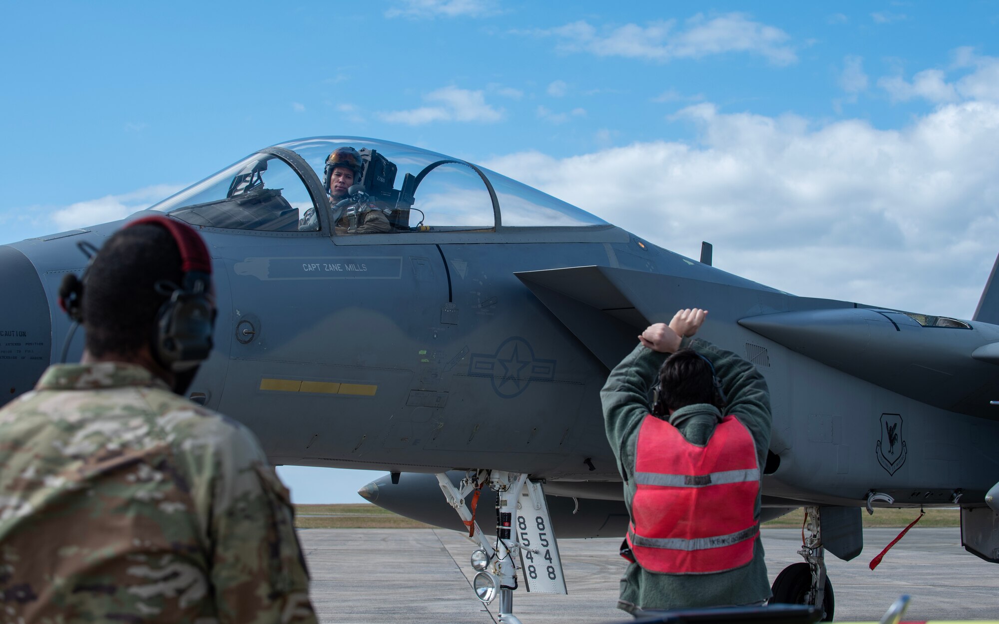 airmen signals to a pilot in a fighter jet