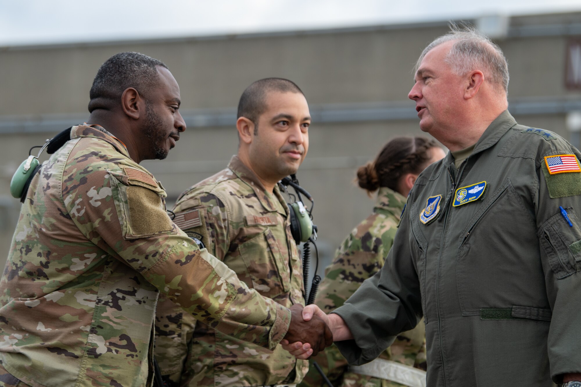 Two service members shake hands.