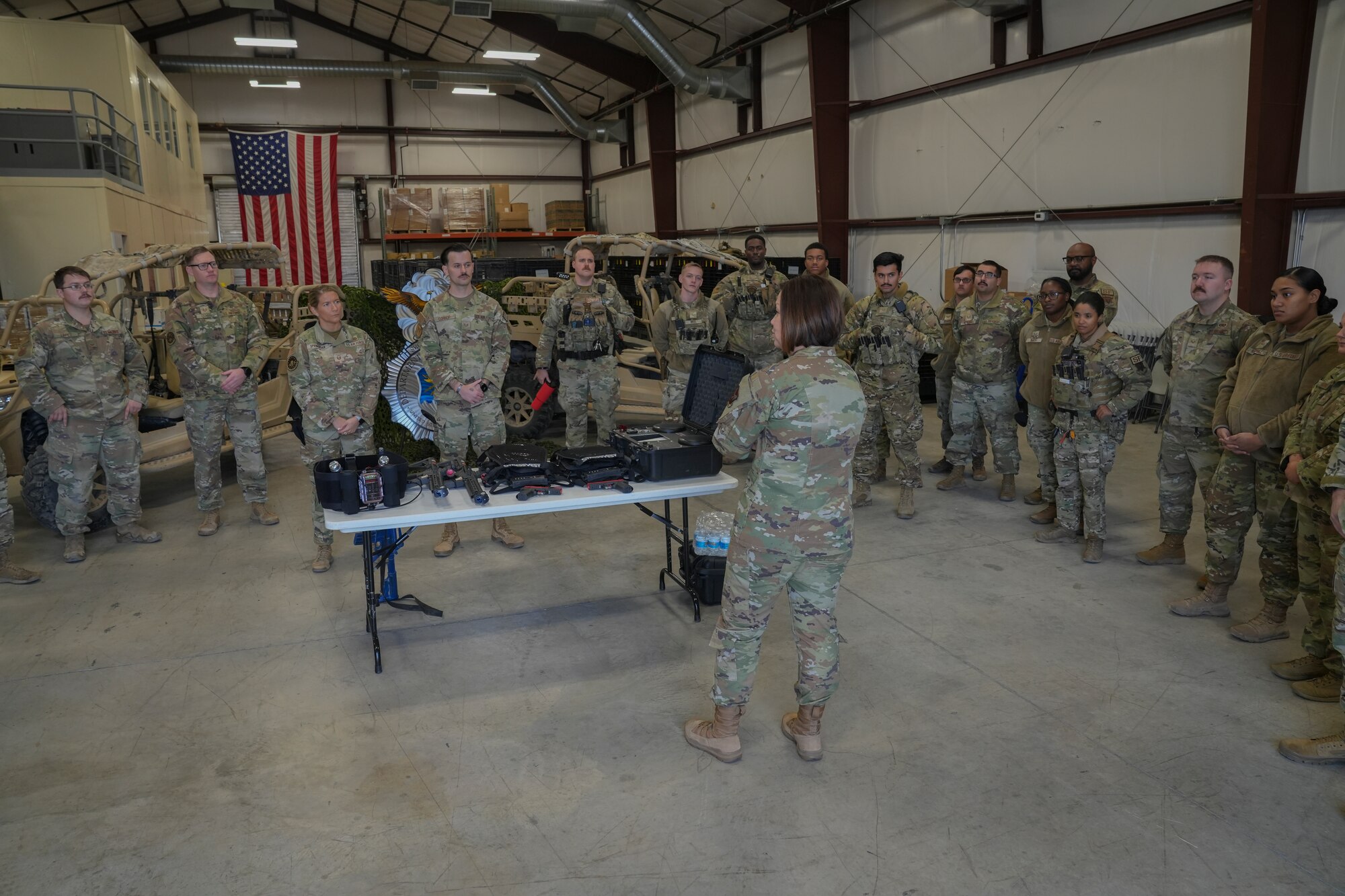 Chief Bass speaks to the 432nd Security Forces Squadron and they stand around her in a circle/