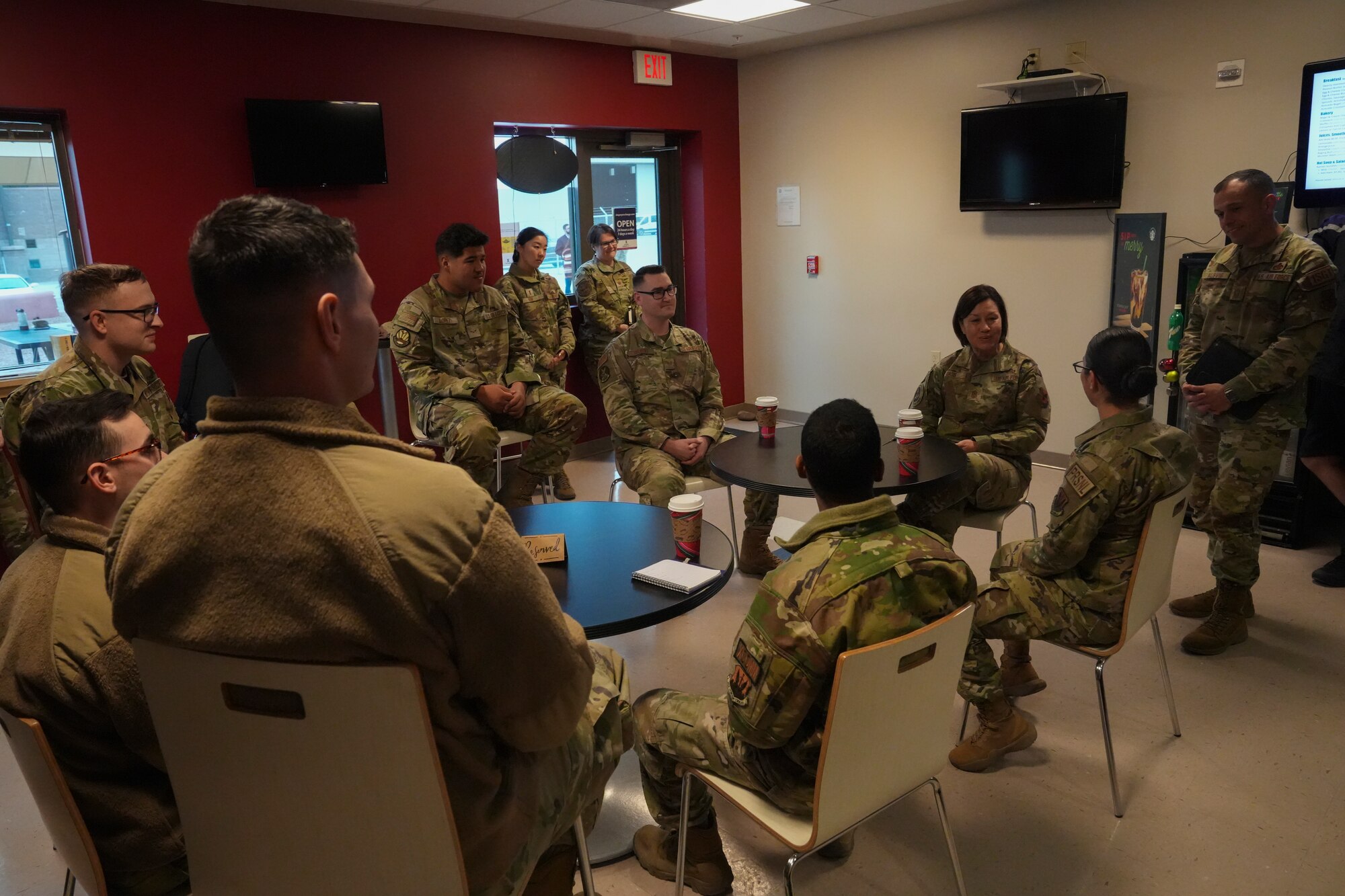 Chief Bass speaks to airmen in a coffee shop.