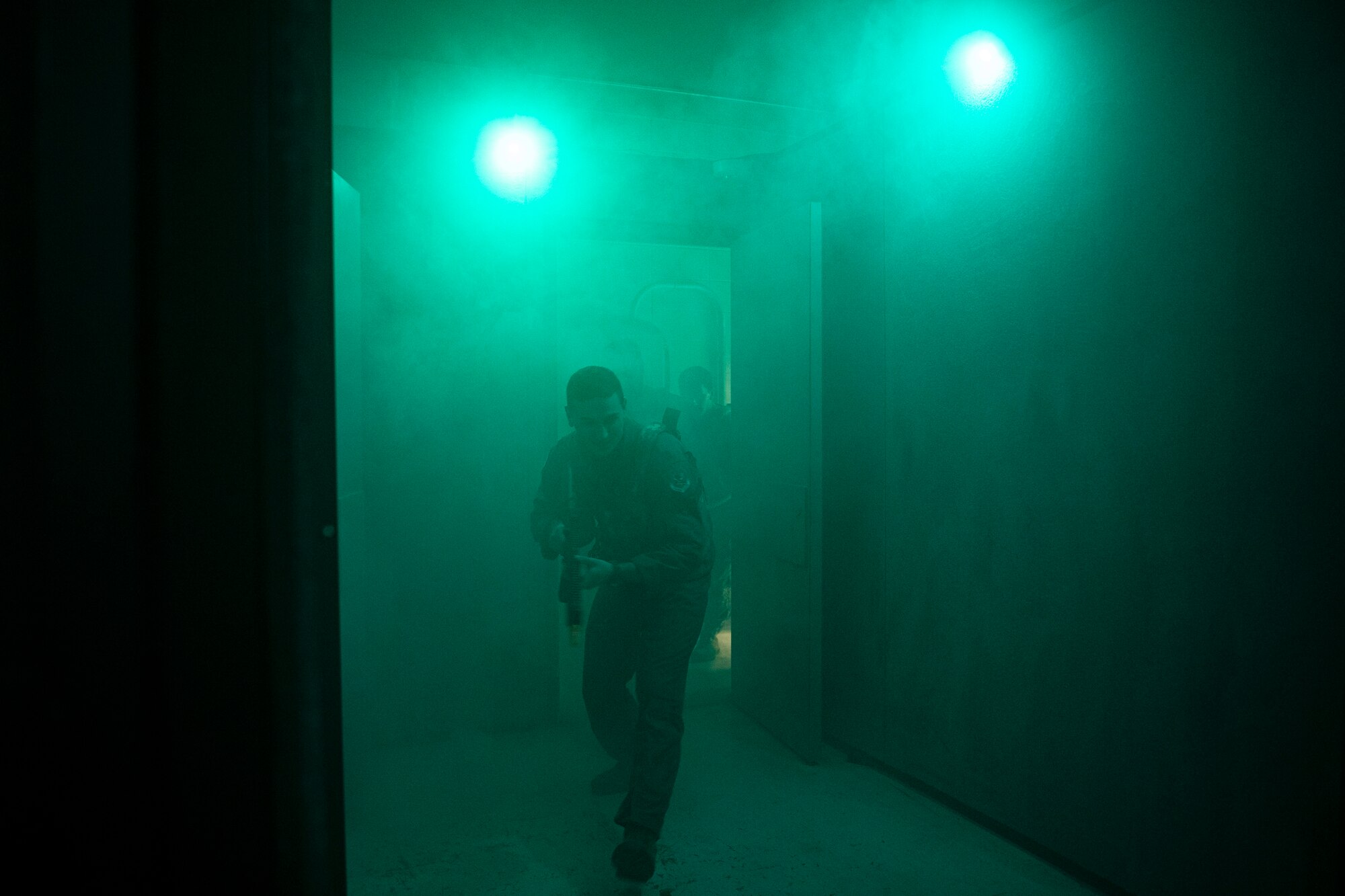 Airman enters simulated scenario with fog and simulated gun shots