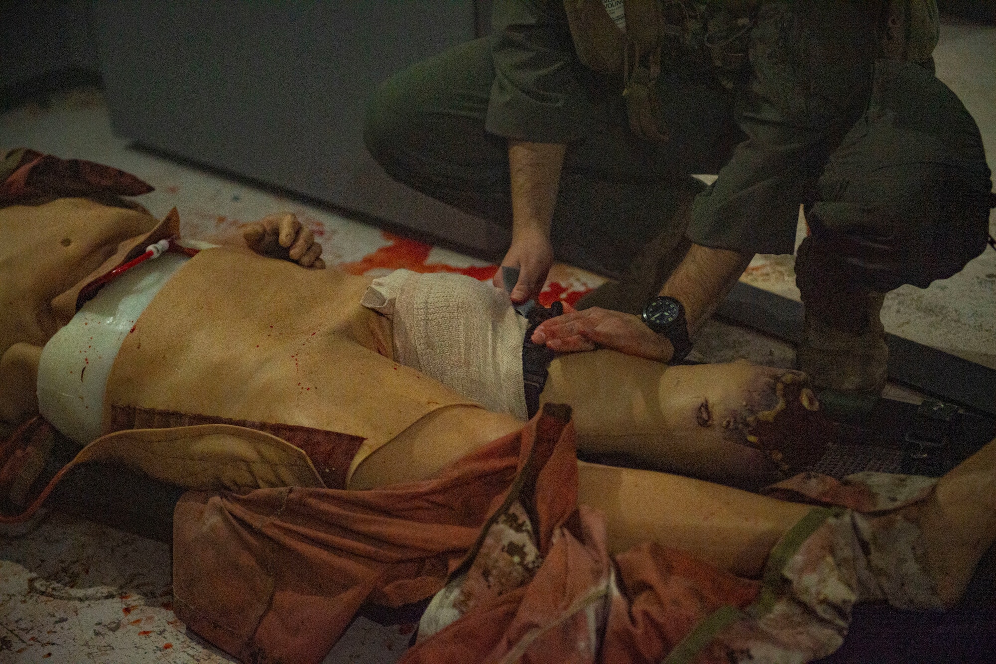 Airman tightens tourniquet around a simulated casualty.