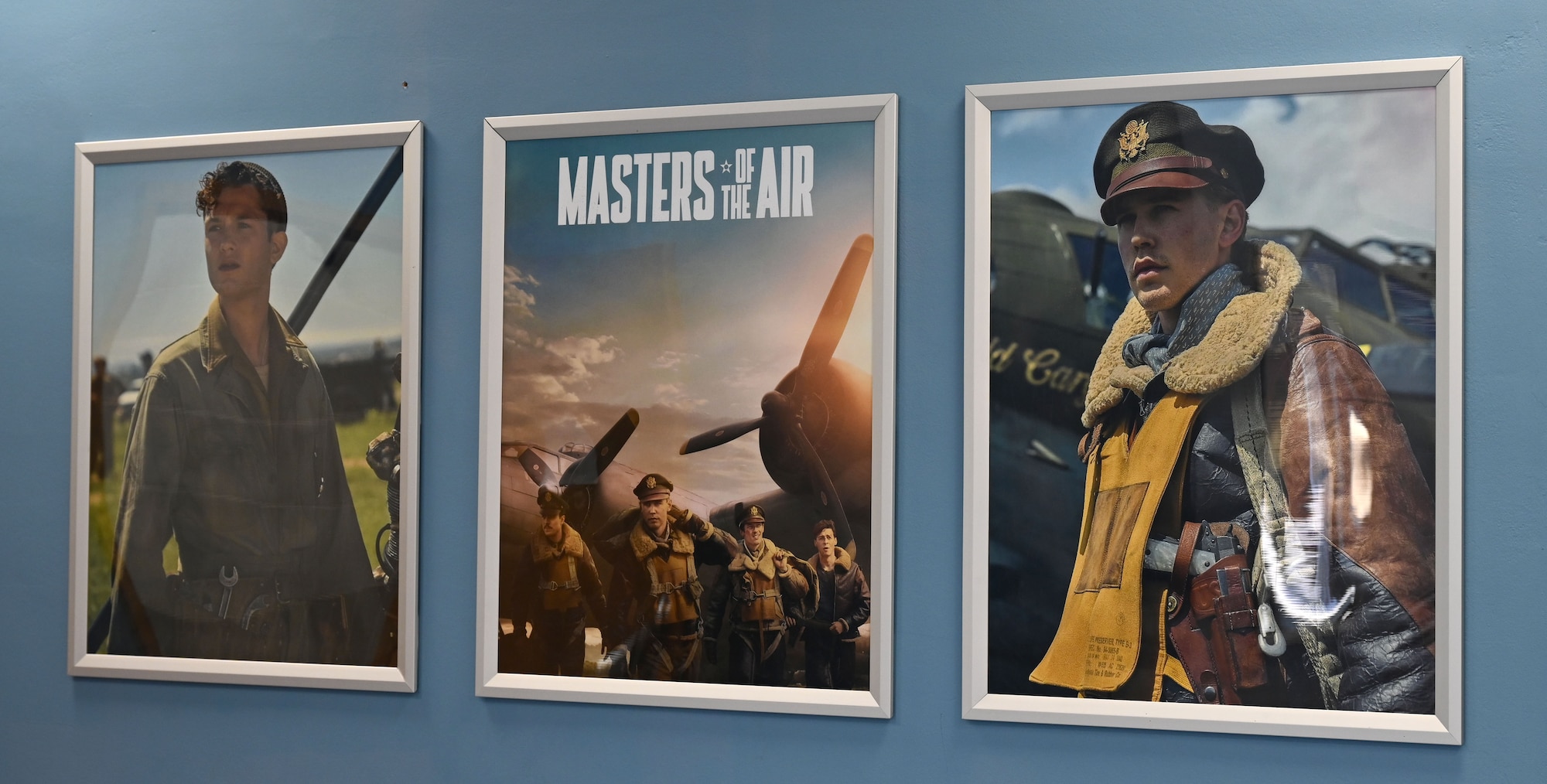 Posters showing scenes from the new miniseries, “Masters of the Air,” are displayed at the base theater for a special premiere of the first episode at Royal Air Force Mildenhall, England, Jan. 19, 2024. The upcoming nine-part series on Apple TV+ highlights the legacy of the Eighth Air Force and 100th Bomb Group at Thorpe Abbotts, England, to which the 100th ARW has direct ties. (U.S. Air Force photo by Karen Abeyasekere)