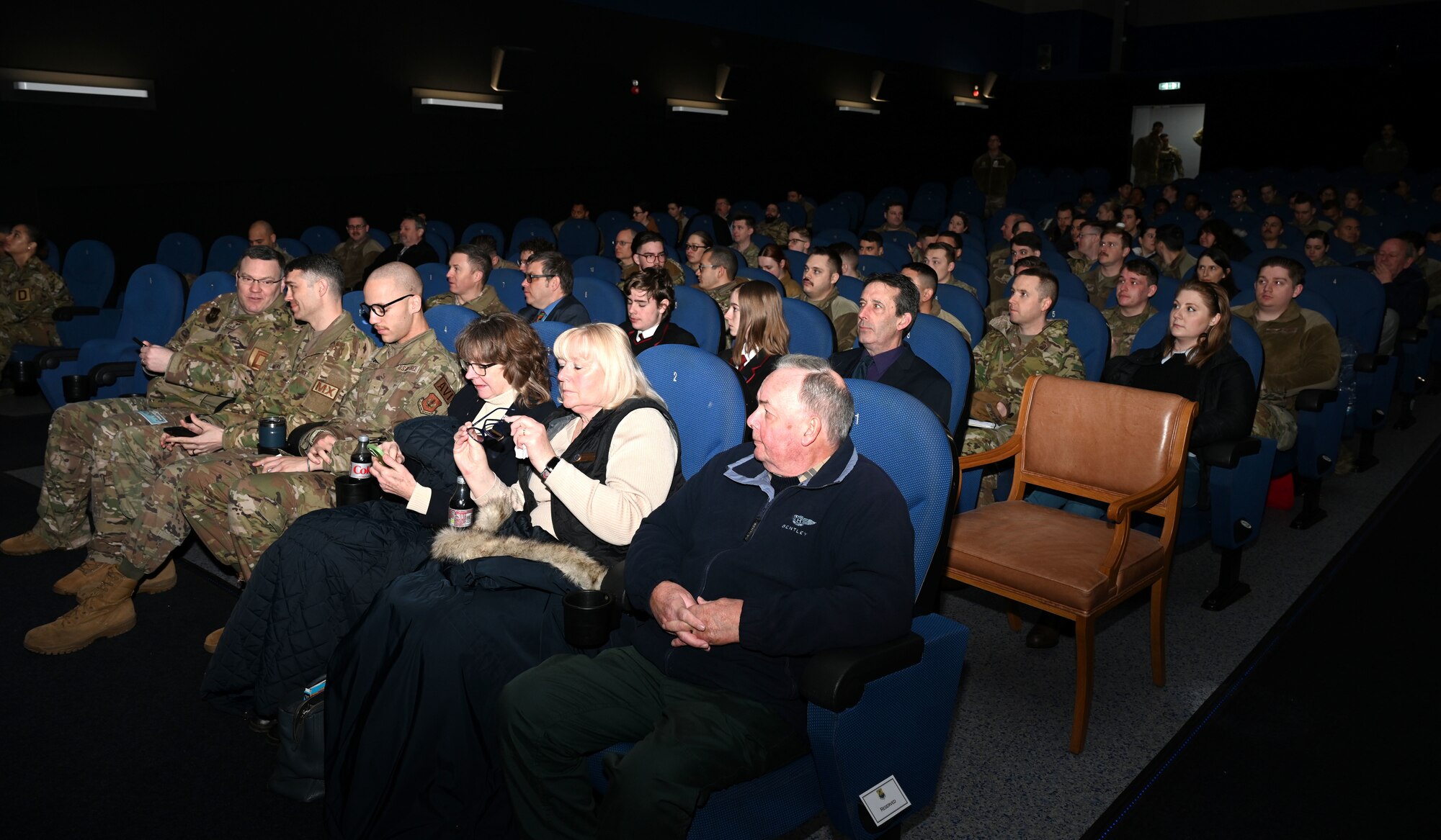 U.S. Air Force Airmen, civilians and invited guests prepare to watch a special premiere of the first episode of the upcoming “Masters of the Air” miniseries at Royal Air Force Mildenhall, England, Jan. 19, 2024. The upcoming nine-part series on Apple TV+ highlights the legacy of the Eighth Air Force and 100th Bomb Group at Thorpe Abbotts, England, to which the 100th ARW has direct ties. (U.S. Air Force photo by Karen Abeyasekere)