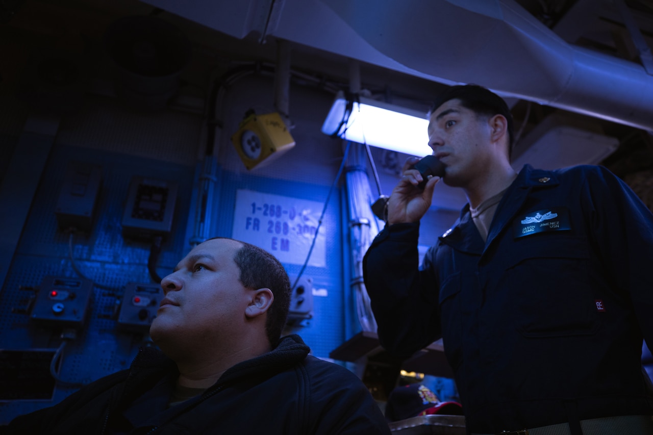 Sailors monitor systems aboard a ship.