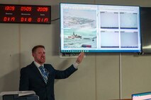 A photo of Jeffrey Gehringer pointing to video feeds.