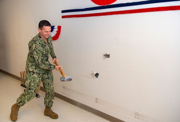 Naval Medical Center Portsmouth (NMCP) hosts an OR (operating room) construction project groundbreaking ceremony, Jan. 18. Cmdr. Gregory Capra, NMCP’s Director of Surgical Services (DSS) directorate head, takes a swing with a sledgehammer to add to the efforts to kickoff construction.