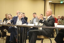 Honorable Ann Dunkin and Mr. Robert Kazimer discuss cyber training at a table during a conference.