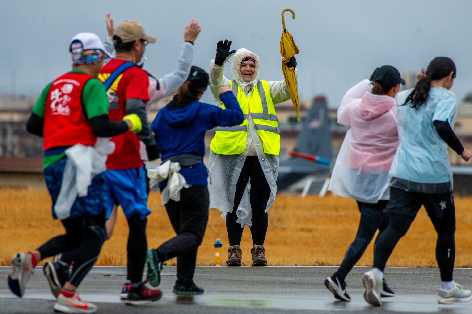 A volunteer cheers on runners.