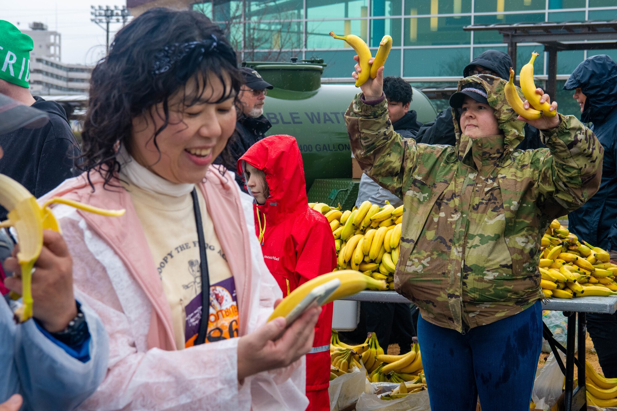 A volunteer hands out bananas.