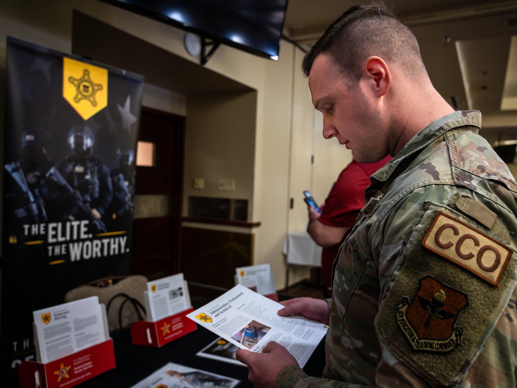 U.S. Air Force Staff Sgt. Jonathan Mullen, 56th Contracting Squadron contracting officer, reviews a flyer during the Hiring our Heroes Career Expo, Jan 18, 2024 at Luke Air Force Base, Arizona.