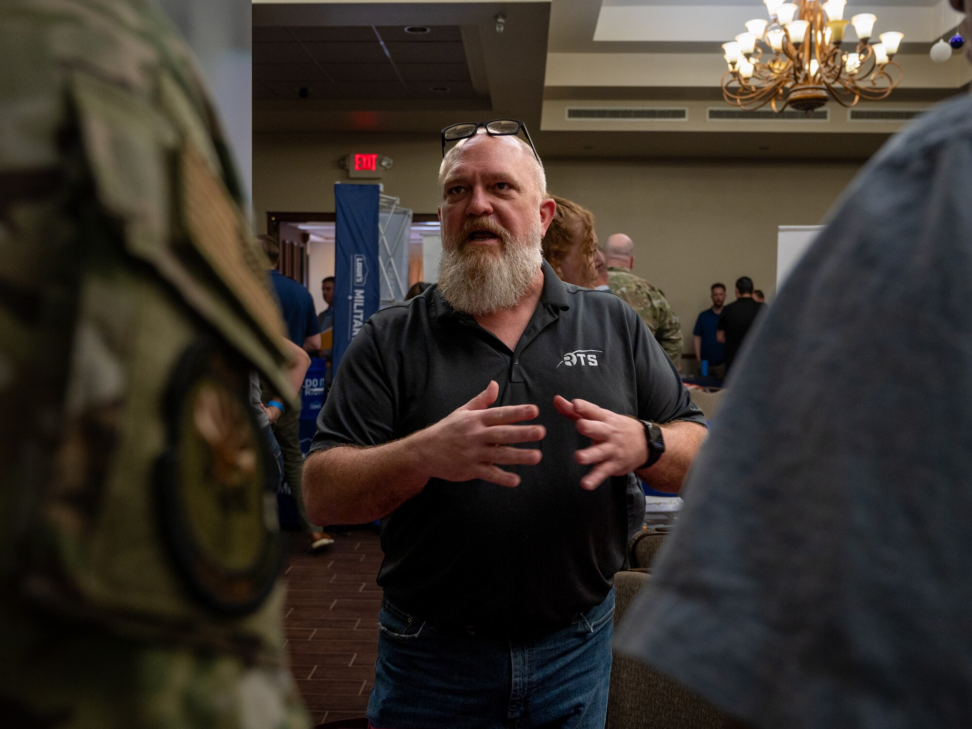 Shane Hollander, Rubicon Technical Services program manager, speaks with service members during the Hiring our Heroes Career Expo, Jan 18, 2024 at Luke Air Force Base, Arizona.