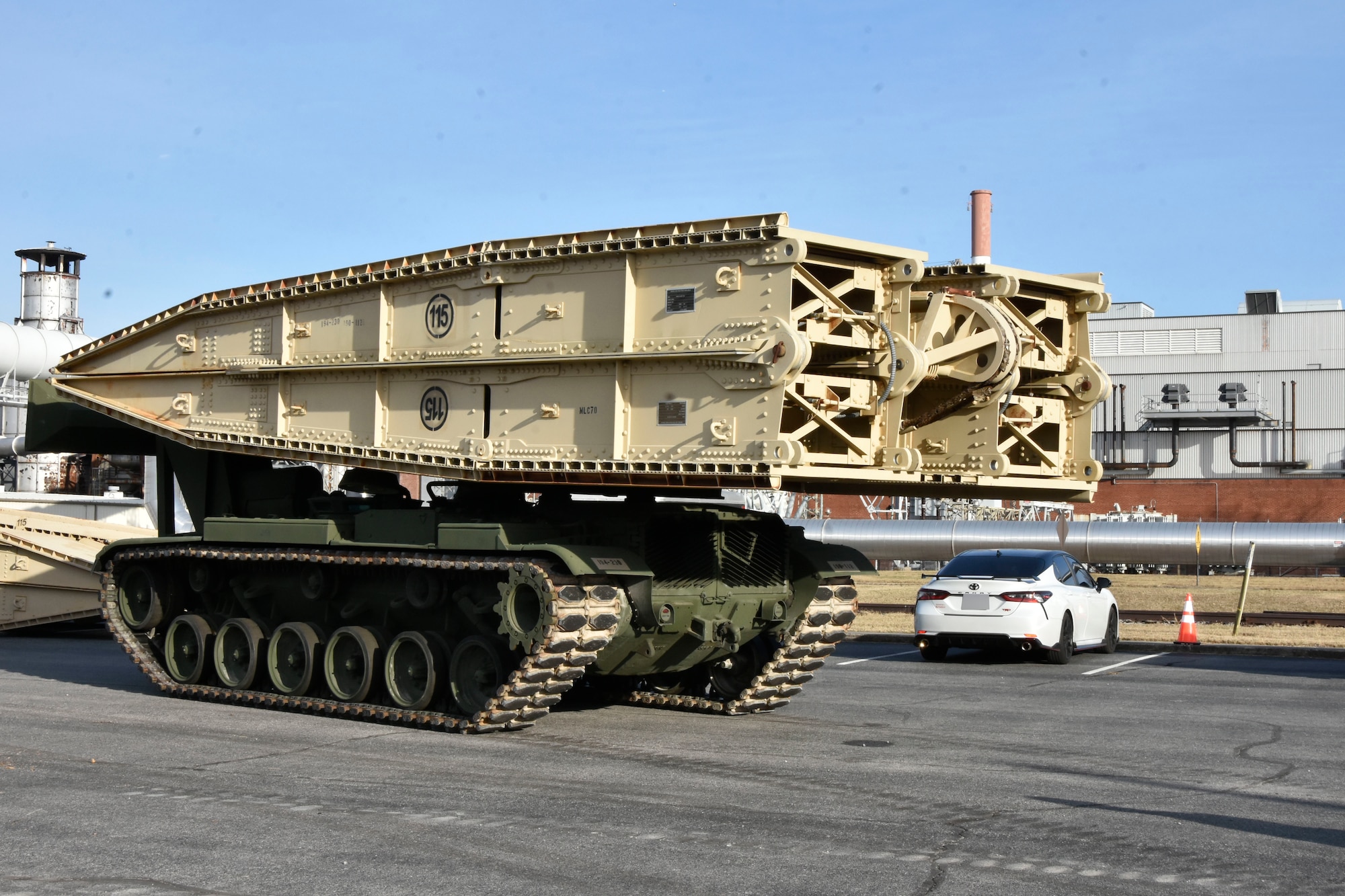 An Armored Vehicle Launched Bridge arrives at Arnold Air Force Base, Tenn., Nov. 30, 2023. AVLBs carry a deployable bridge and are designed to allow tanks, infantry fighting vehicles and other tactical vehicles to cross small rivers, gaps and other terrain obstacles on the battlefield. The AVLB was commercially delivered from Fort Campbell, Ky., and was needed to move a large crane across an Arnold alleyway where the axle load limit was less than the weight of the crane. The bridge component of the AVLB was emplaced on Jan. 6, 2024, to allow the crane entrance into the work area. The AVLB was operated by a Guardsman with the 190th Engineer Company of the Tennessee National Guard, while Guardsmen from the 194th Engineer Brigade directed and guided the operation. (U.S. Air Force photo by Bradley Hicks) (This image was altered by obscuring a vehicle license plate)
