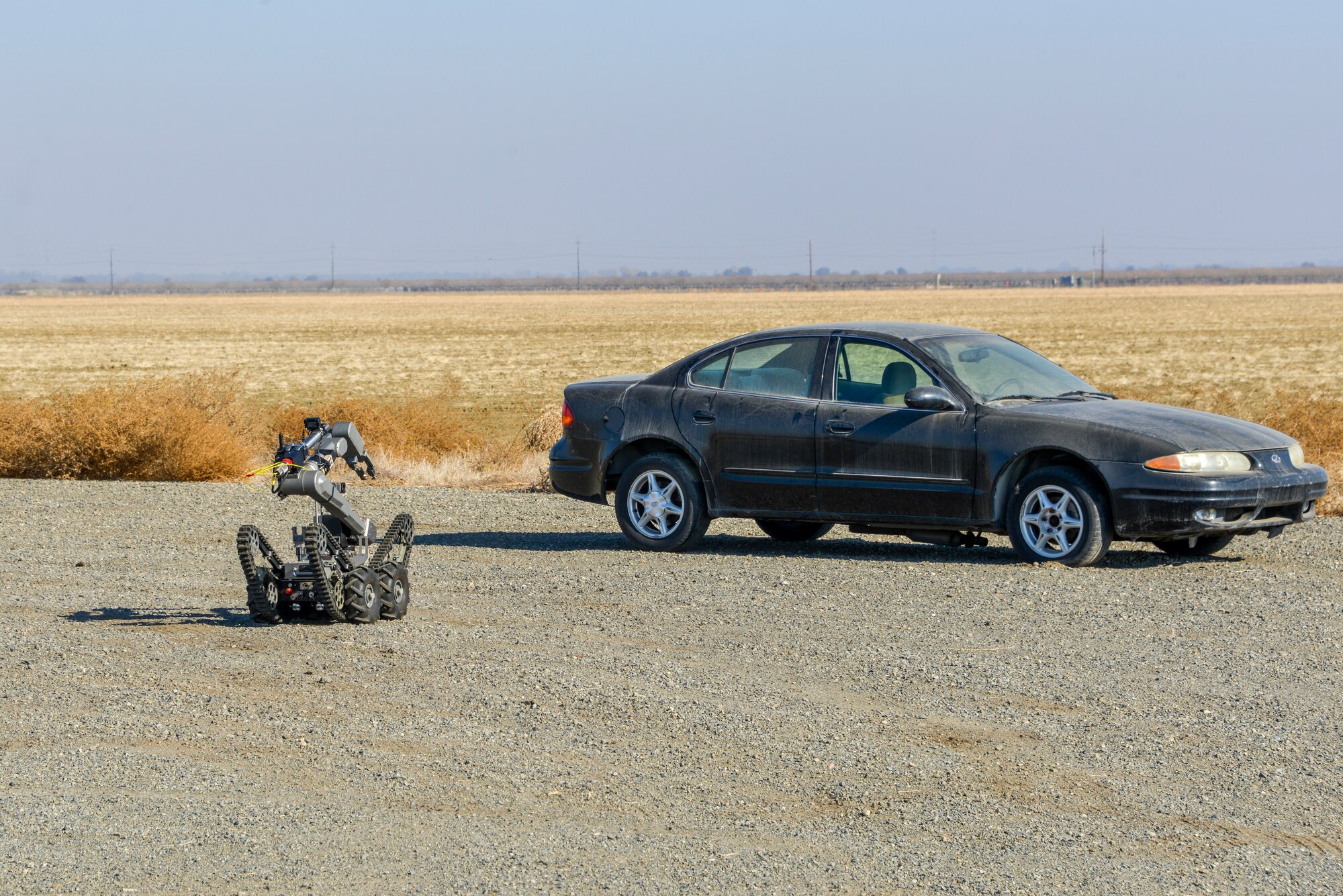 An EOD robot approaches an abandoned car.