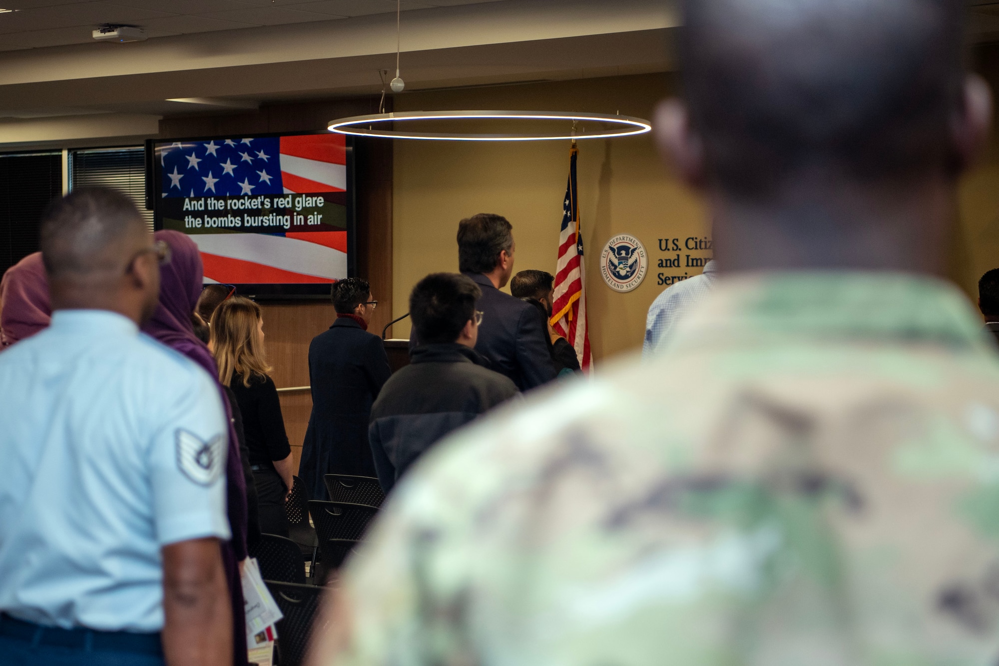 North Carolina Air National Guard recruiters stand at attention during the national anthem at a naturalization ceremony.