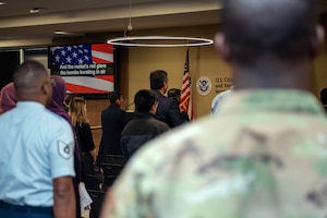 North Carolina Air National Guard recruiters stand at attention during the national anthem at a naturalization ceremony.