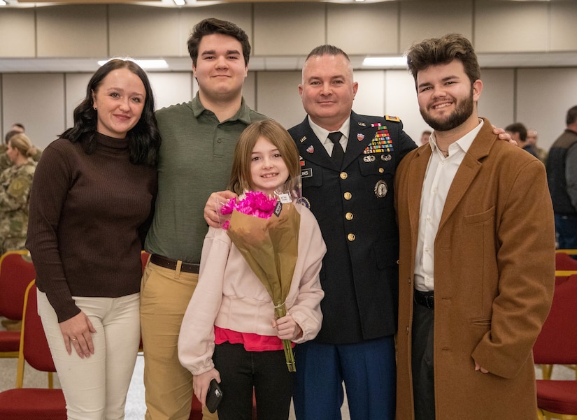 Chief Warrant Officer Four Timothy Collins stands with his family during his promotion ceremony at the Wellman Auditorium on Boone Center in Frankfort, Kentucky, Jan. 22, 2024.