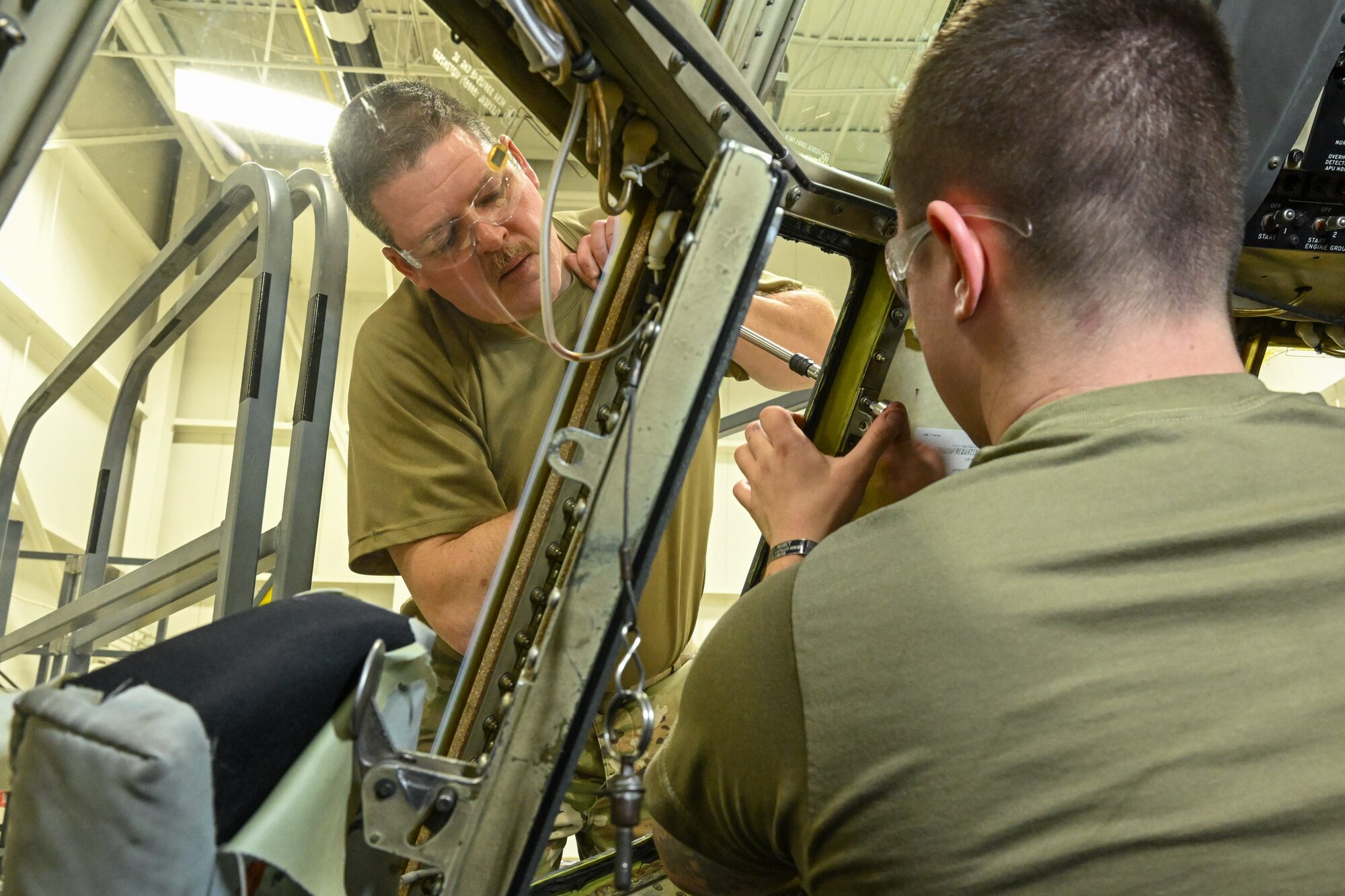 Master Sgt. Dan Scott, 910th Maintenance Squadron aircraft maintenance craftsman, and Staff Sgt. Creston Shirey, 910th Maintenance Squadron aircraft maintenance journeyman, install a new window on a C-130H Hercules aircraft at Youngstown Air Reserve Station, Ohio, Jan. 24, 2024.