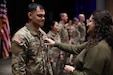 Spc. Phillip Gallardo gets promoted to sergeant by his mother, Fawn, doing the going away ceremony for 1st Platoon, 299th Chemical Company, 149th Maneuver Enhancement Brigade at Ryle High school in Union Ky., Jan 13, 2024.  There was one more specialist that was promoted to sergeant alongside Gallardo as well as a sergeant to Staff Sgt. (U.S. Army National Guard photo by Sgt. 1st Class Benjamin Crane)