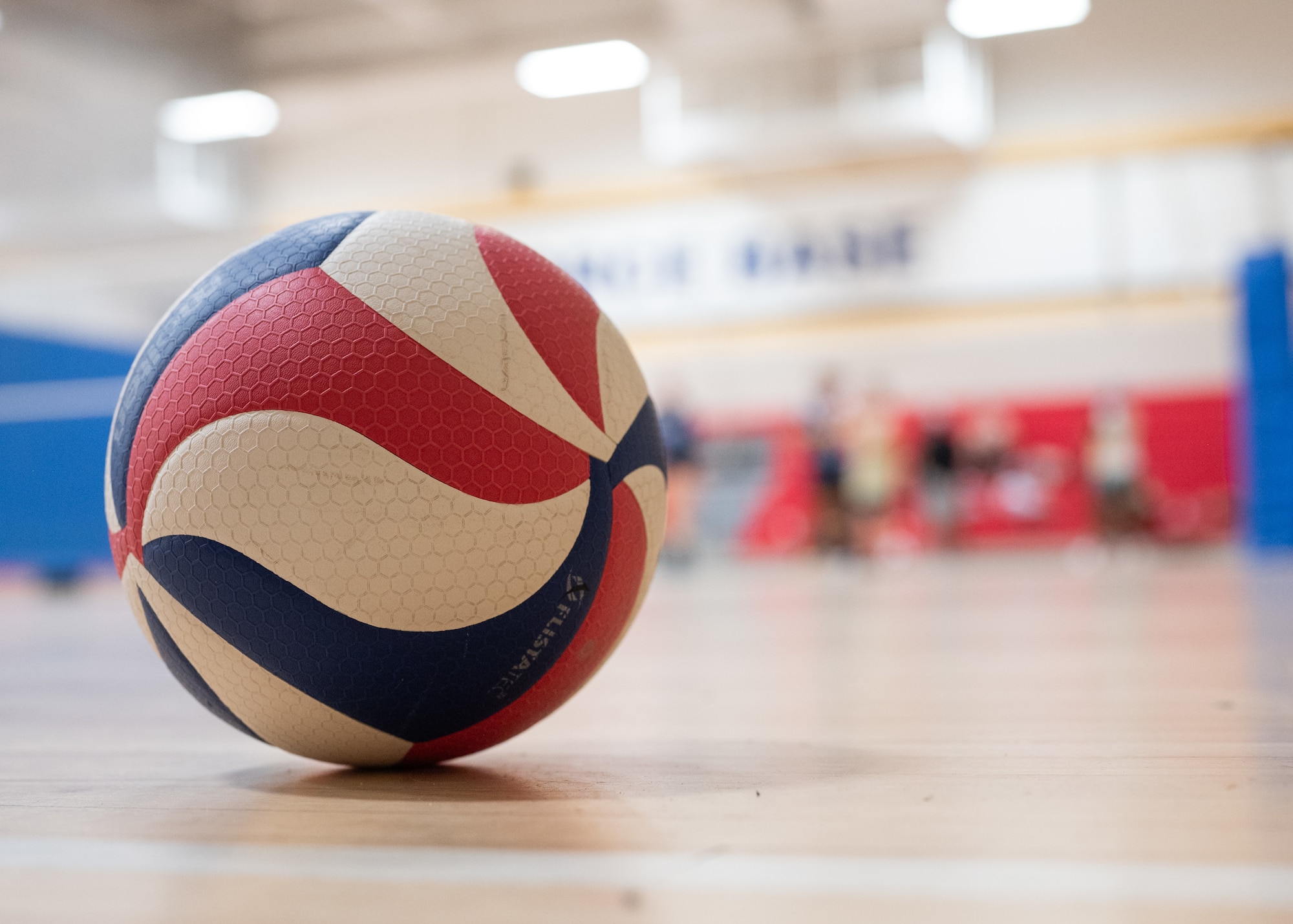 A volleyball sits stationary on the court after a game