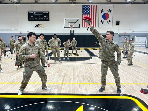 Capt. Evan P. Shortsleeve (right), the commander of the 59th Chemical, Biological, Radiological, Nuclear (CBRN) Company (Hazards Response), holds a pad for Sgt. Robert J. Errington (left). Errington took first place during the international competition at the Kukkiwon, the World Taekwondo Headquarters in Seoul. Courtesy photo.