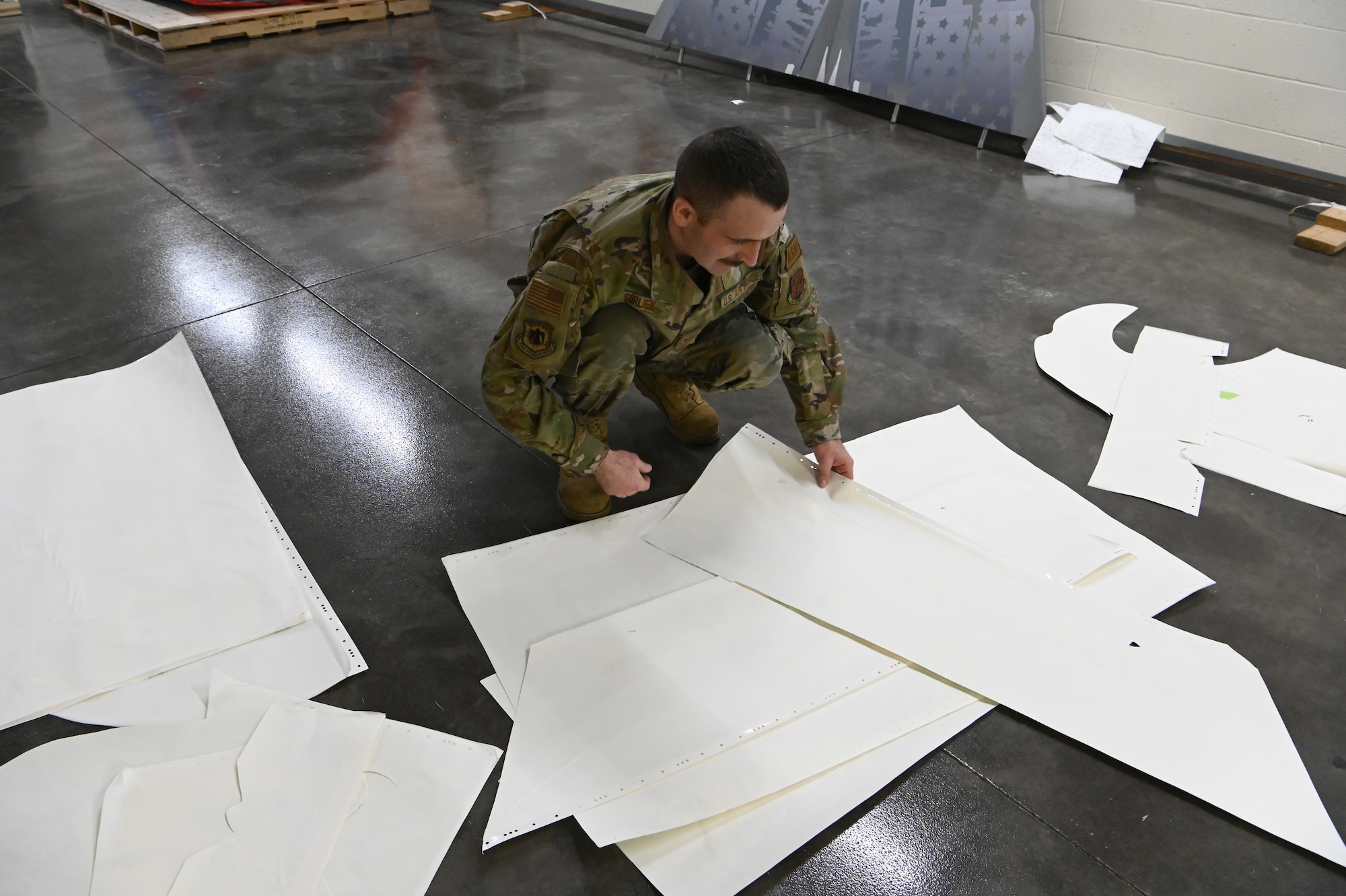 U.S. Air Force Staff Sgt. Drew Sorlien, a structural maintenance technician with the 173rd Maintenance Squadron, organizes the Kingsley Field eagle tail flash stencils before placement on the F-15C begins.