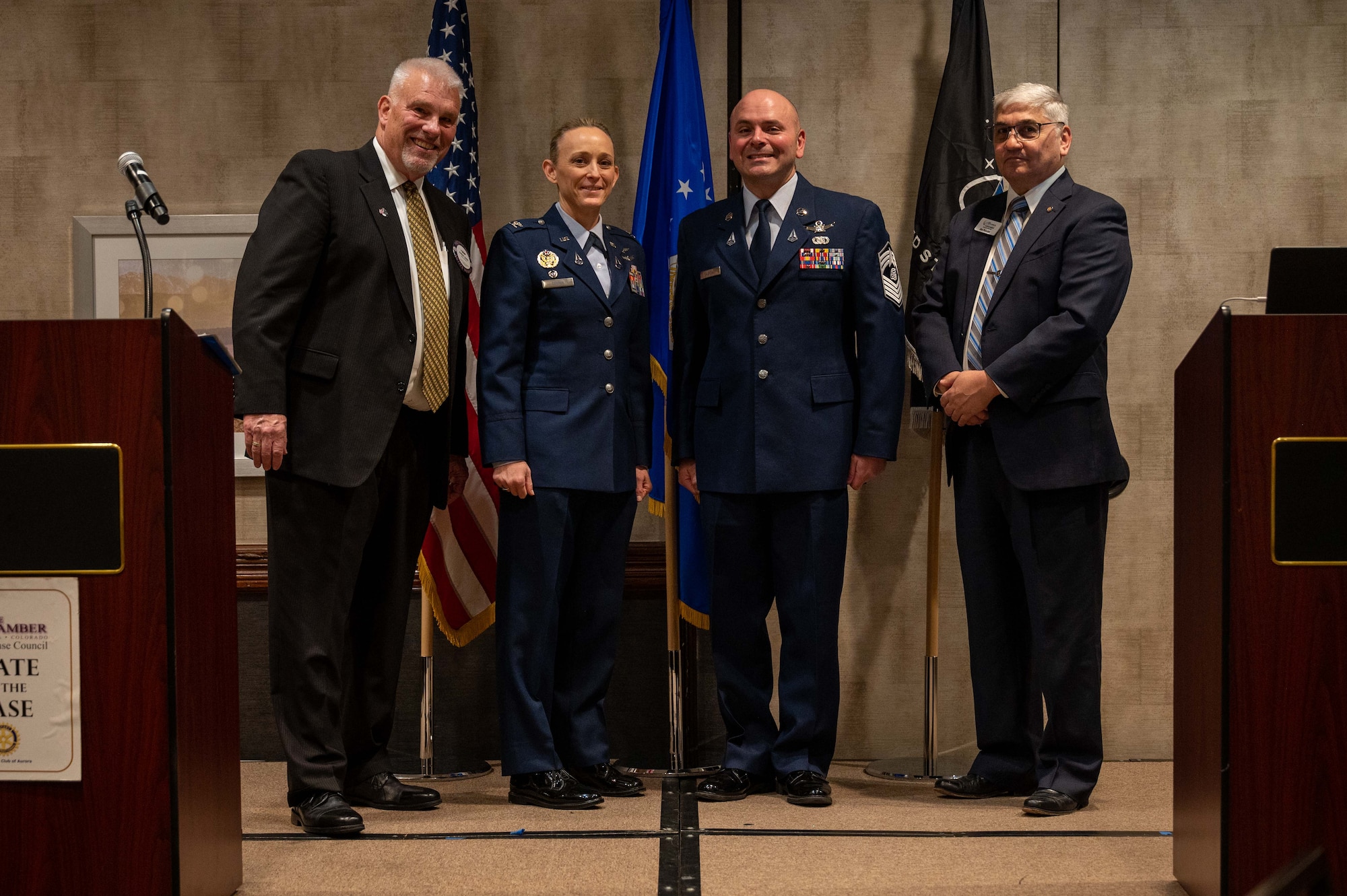 servicemembers stand on a podium with community members