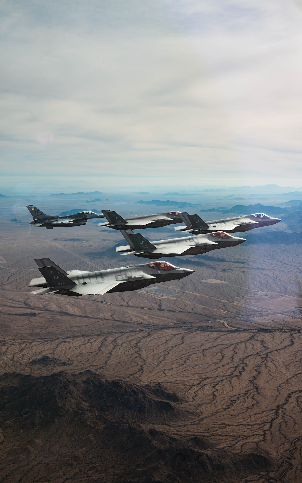 U.S. Air Force F-35A Lightning II’s assigned to the 61st Fighter Squadron and an F-16 Fighting Falcon aircraft assigned to the 309th Fighter Squadron, fly in formation, Jan. 19, 2024, over Luke Air Force Base, Arizona.